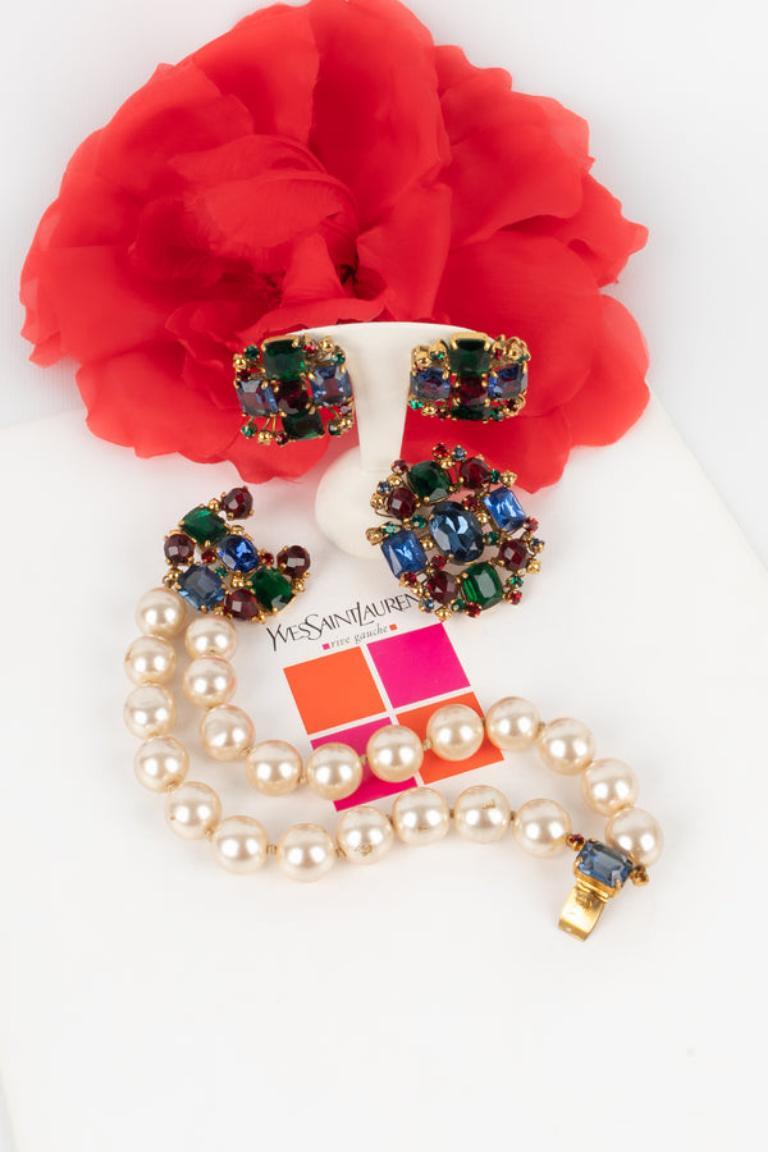 Scemama - Golden metal set composed of a bracelet, a brooch, and earrings with multicolored rhinestones and costume pearls. To be mentioned, the costume pearls of the bracelet are worn.

Additional information:
Condition: Good condition
Dimensions: