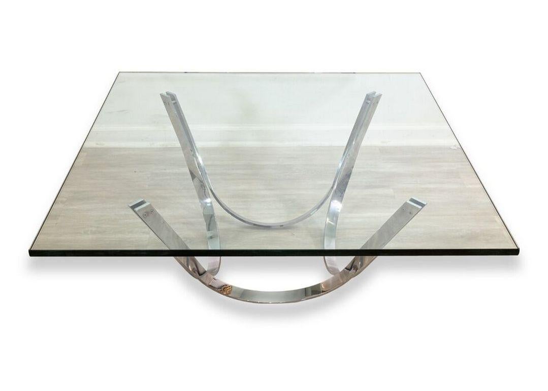 A Roger Sprunger 1970s modern chrome base square glass top cocktail coffee table. A wonderfully contemporary coffee table featuring a thick, square glass table top, and a chrome finished base with four swooping sides. This piece is in very good
