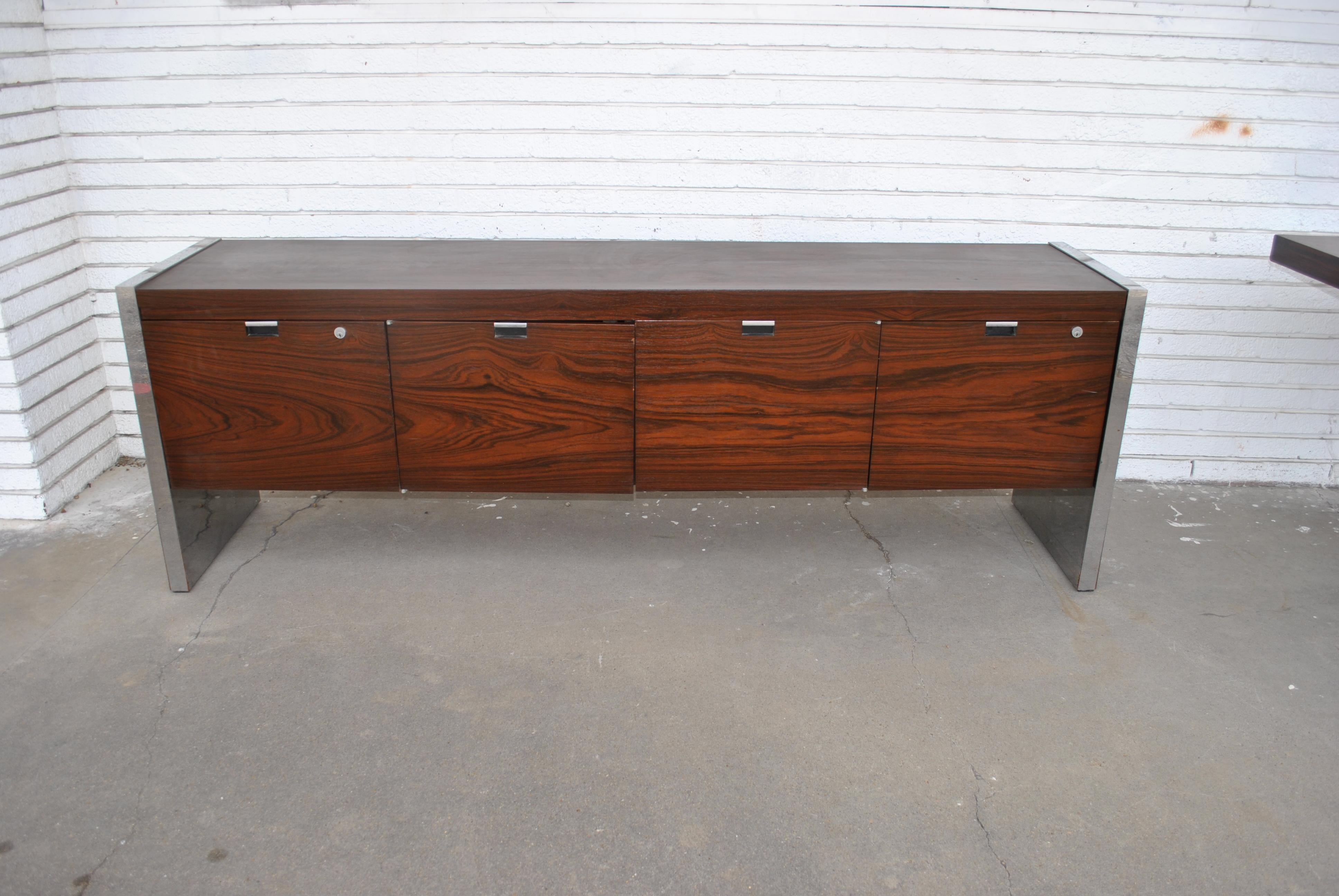 Roger Sprunger for Dunbar rosewood and chrome executive Credenza,
1970s.

A Mid-Century Modern rosewood and chrome credenza with generous storage and shelving.
Six drawers and two file cabinets. Rich rosewood case with polished chrome