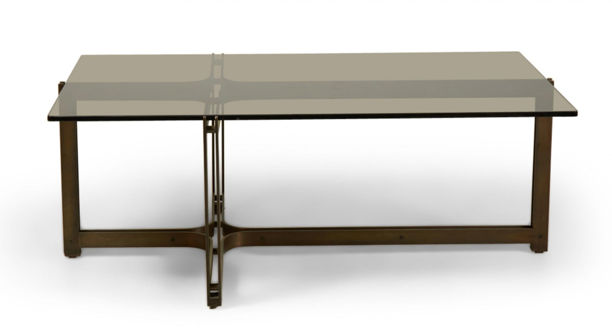 American Mid-Century (1960s) rectangular cocktail / coffee table with an inset smoked glass top supported by a bronze cross-shaped frame with a stretcher base, resting on rosewood feet. (ROGER SPRUNGER FOR DUNBAR)