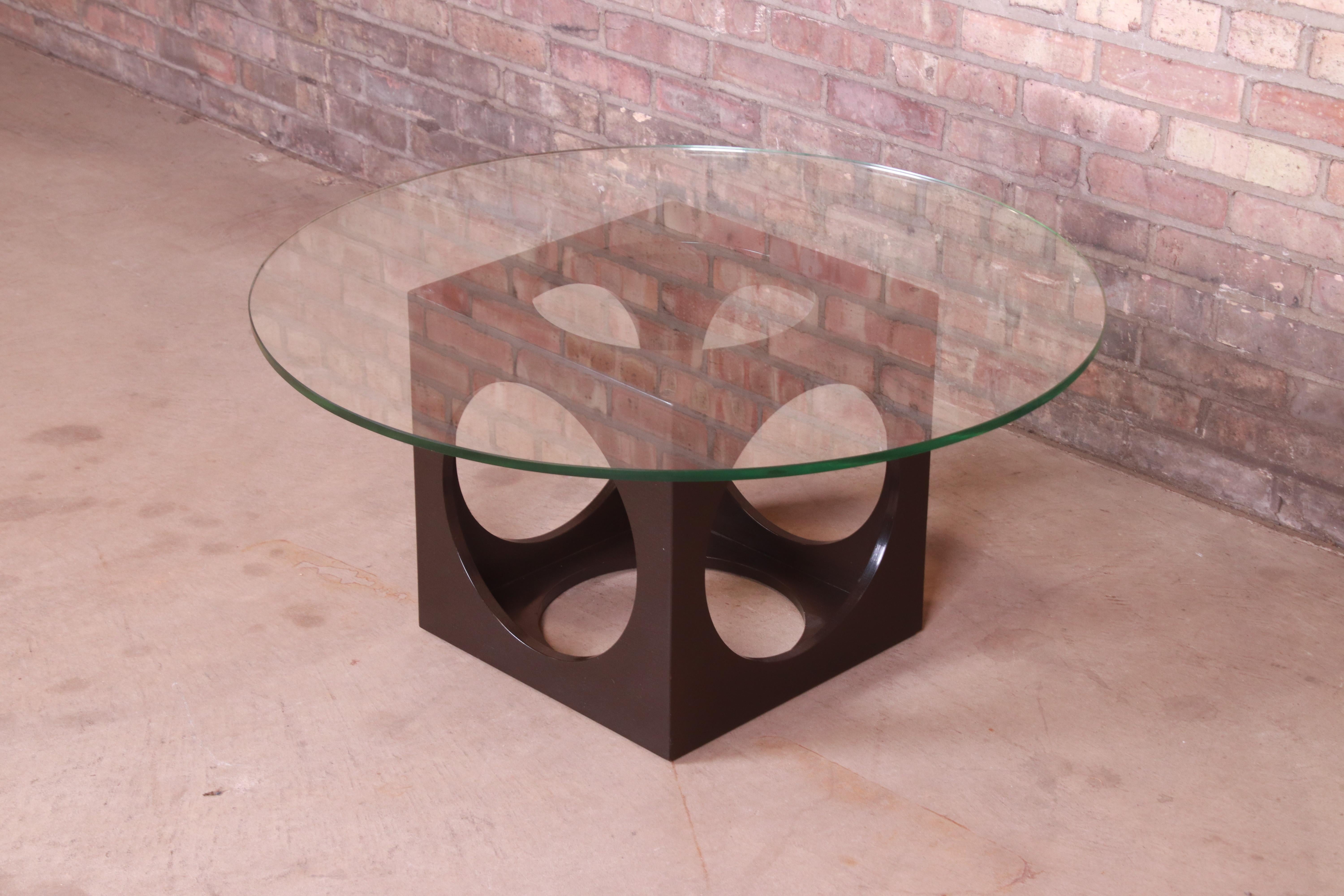 An exceptional Mid-Century Modern geometric cube coffee or cocktail table

By Roger Sprunger for Dunbar Furniture

USA, 1960s

Sculpted walnut cube base, with round glass top.

Measures: 36