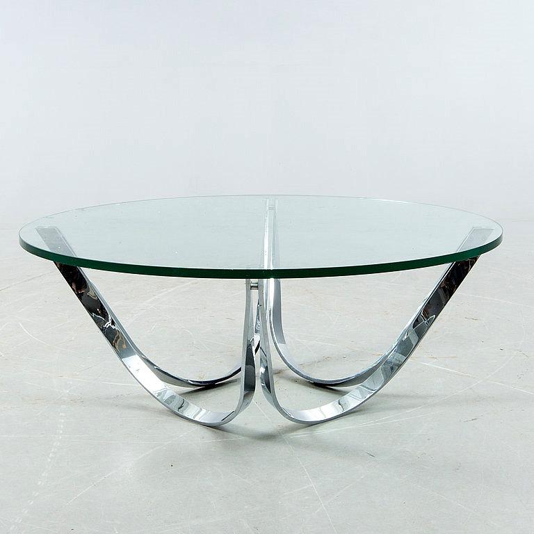 This sculptural cocktail table by Tri-Mark features chrome-plated steel polished to a mirror finish and a round, tempered-glass top.

The base can be inverted or used with square glass for a different look, as seen in the last two images.

These