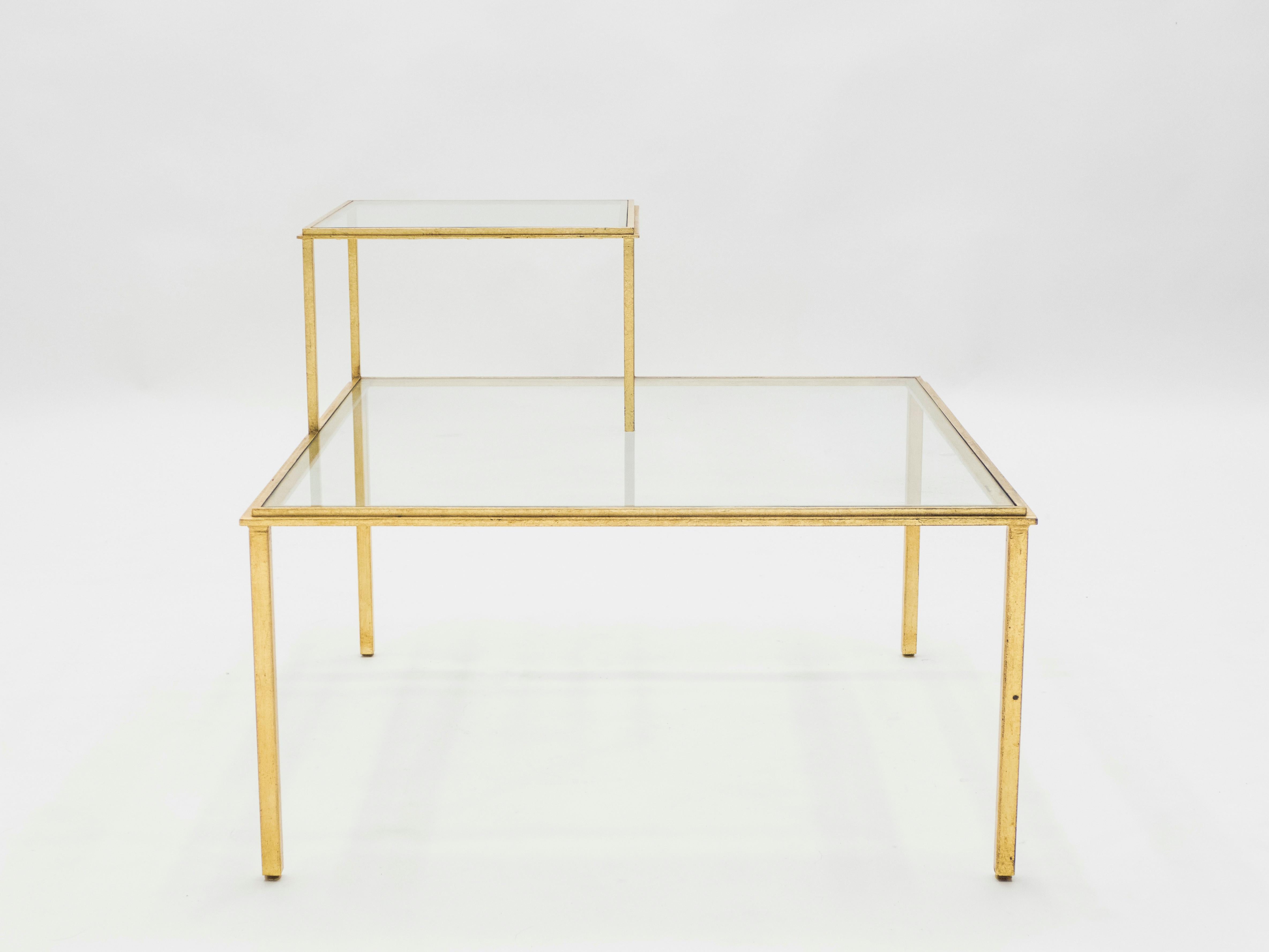 Grace your home with the true elegance of this coffee table or large end table signed and stamped by Roger and Robert Thibier in the 1960s. Glittering in an antiqued gold gilt finish, this original two-tier iron craft coffee table adds a glam twist