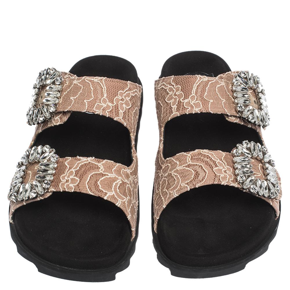 Be ready to catch admiring glances when you step out in this pair of flats by Roger Vivier. They are covered in beige lace and styled with straps that feature crystal embellished buckles. Stand out at day parties with this stunning pair.

