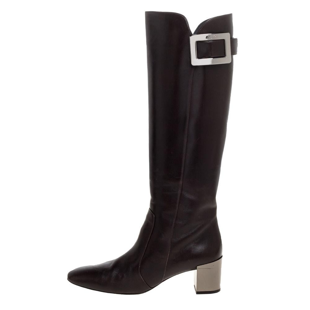 Este atrevido y chic par de botas Roger Vivier tiene una silueta elegante y un diseño sencillo. Estas botas altas hasta la rodilla están confeccionadas en piel de color marrón oscuro y presentan un detalle de hebilla en la parte superior.