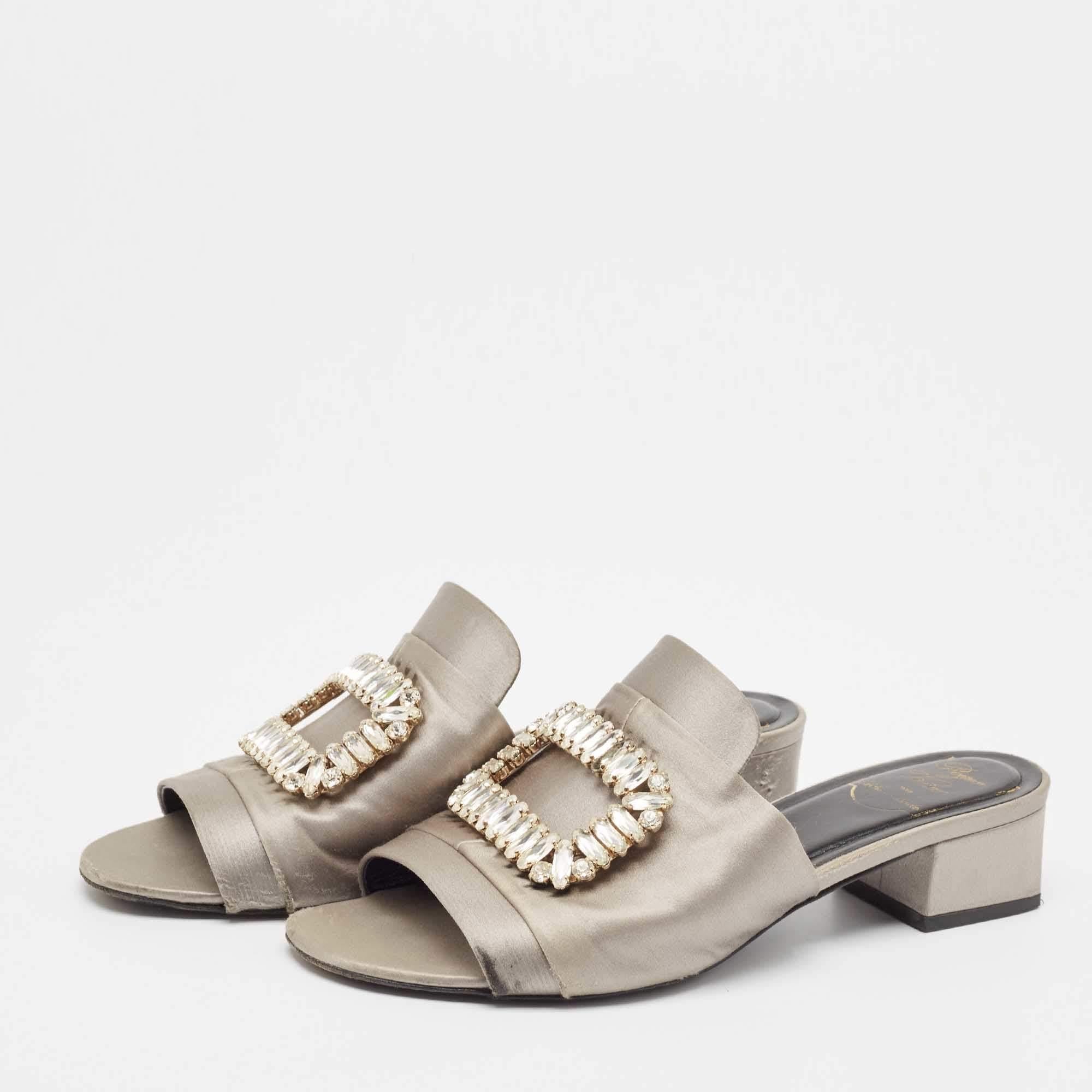Per un aspetto sorprendente, questi sandali di Roger Vivier sono decorati con abbellimenti di cristallo sulla tomaia grigia. Sono realizzate in raso, con punta aperta, vestibilità slip on e tacco di 5 cm.