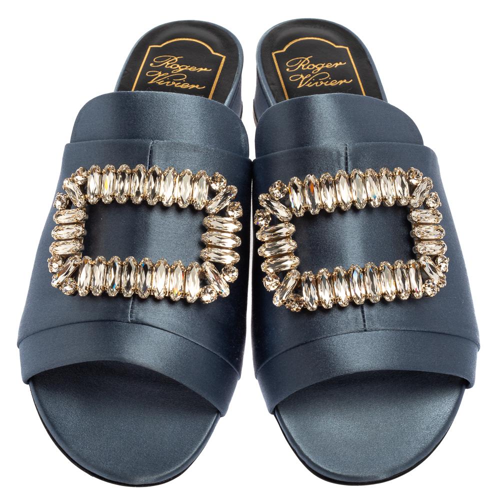 To give you a blissful walk, these Roger Vivier slide sandals come styled with a satin upper, supported by leather-lined insoles and short heels. The pair is finished with sparkly jewels embellished on top.

Includes: Original Dustbag, Original Box
