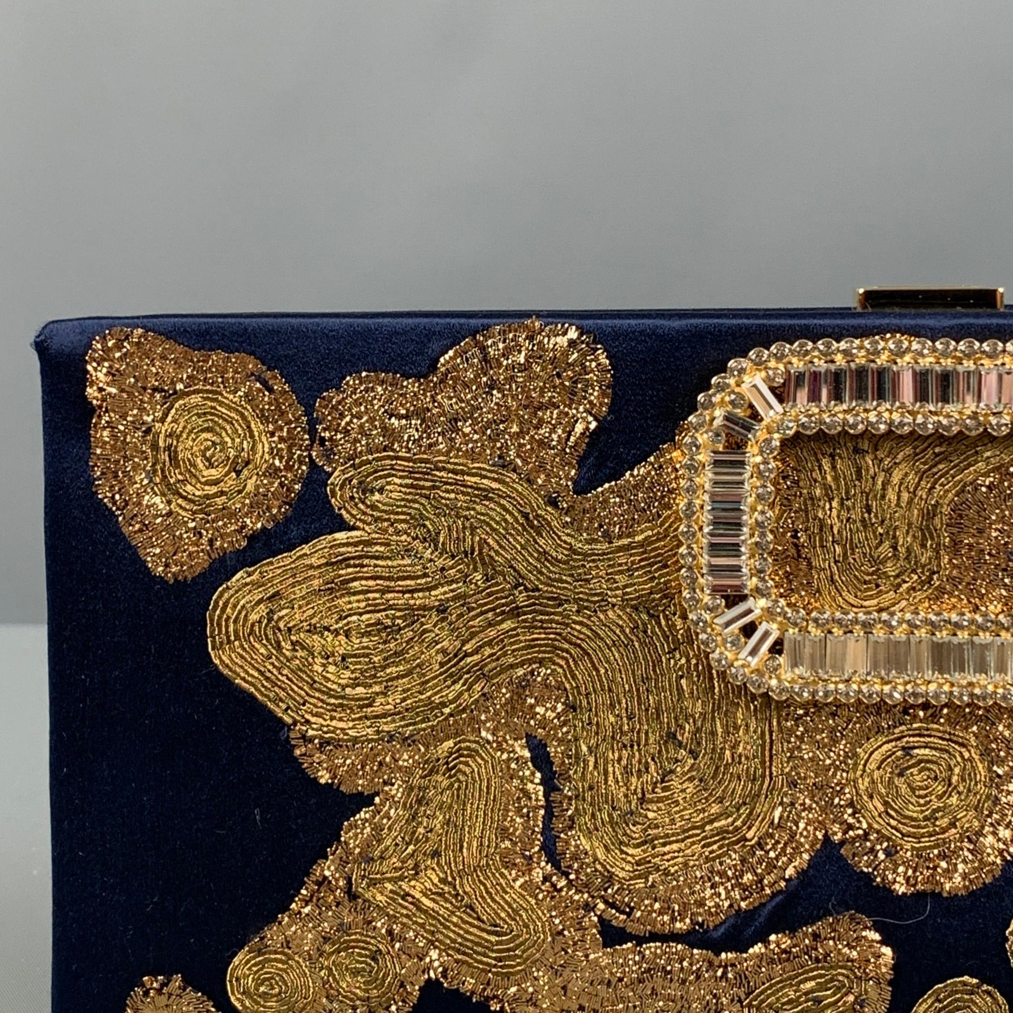 ROGER VIVIER clutch handbag comes in a navy silk featuring gold embroidered design throughout, crystal embellished detail, gold tone shoulder strap, push lock closure. 

Excellent Pre-Owned Condition.
Original Retail Price: