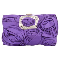 Bolso de mano de Roger Vivier en satén morado con apliques de volantes en forma de rosa en 3D y hebilla de cristal