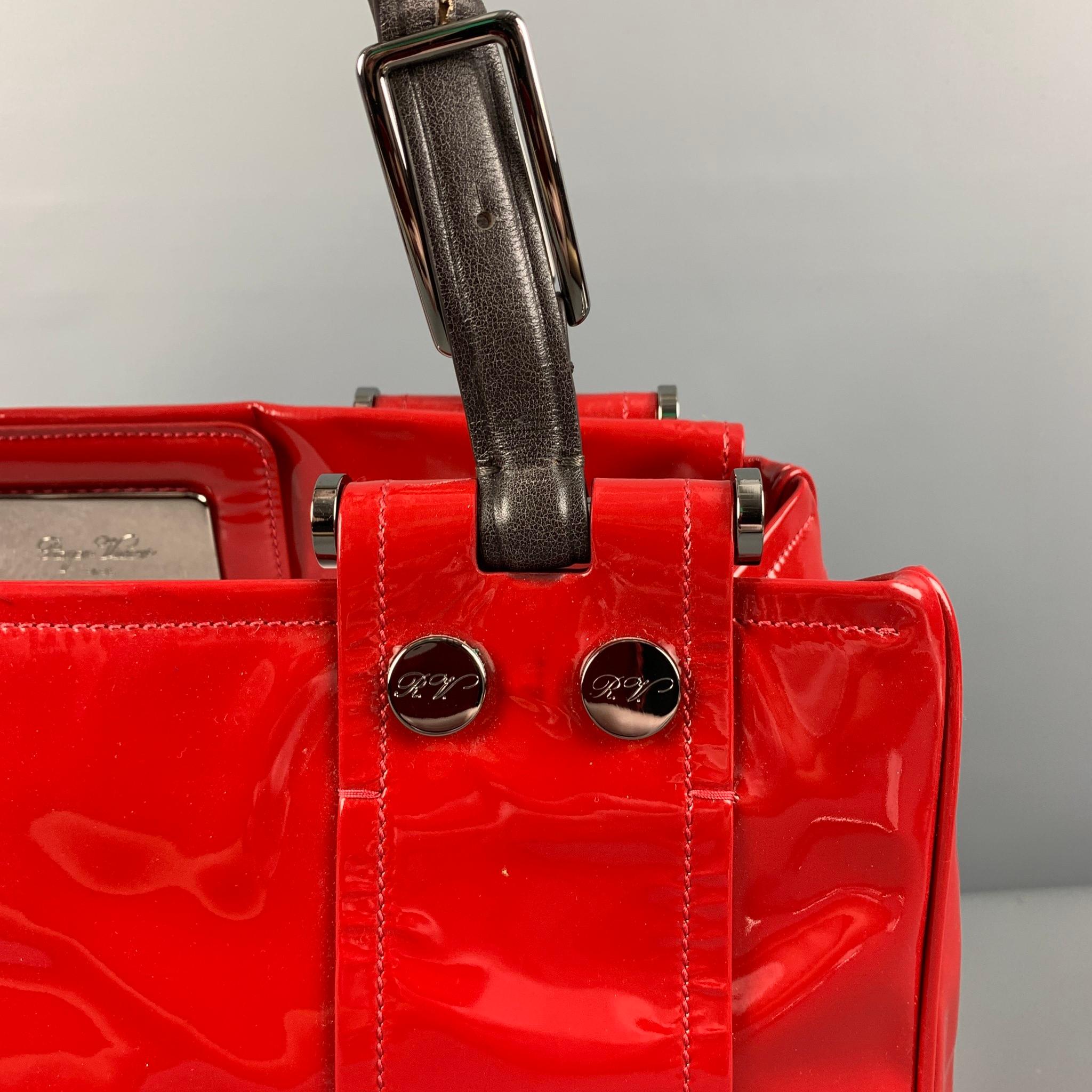 ROGER VIVIER bag comes in a red patent leather featuring brown leather straps, silver tone hardware, dual compartments, inner pockets, and a open top. 

Good Pre-Owned Condition. Moderate discoloration.

Measurements:

Length: 14.5 in.
Width: 4