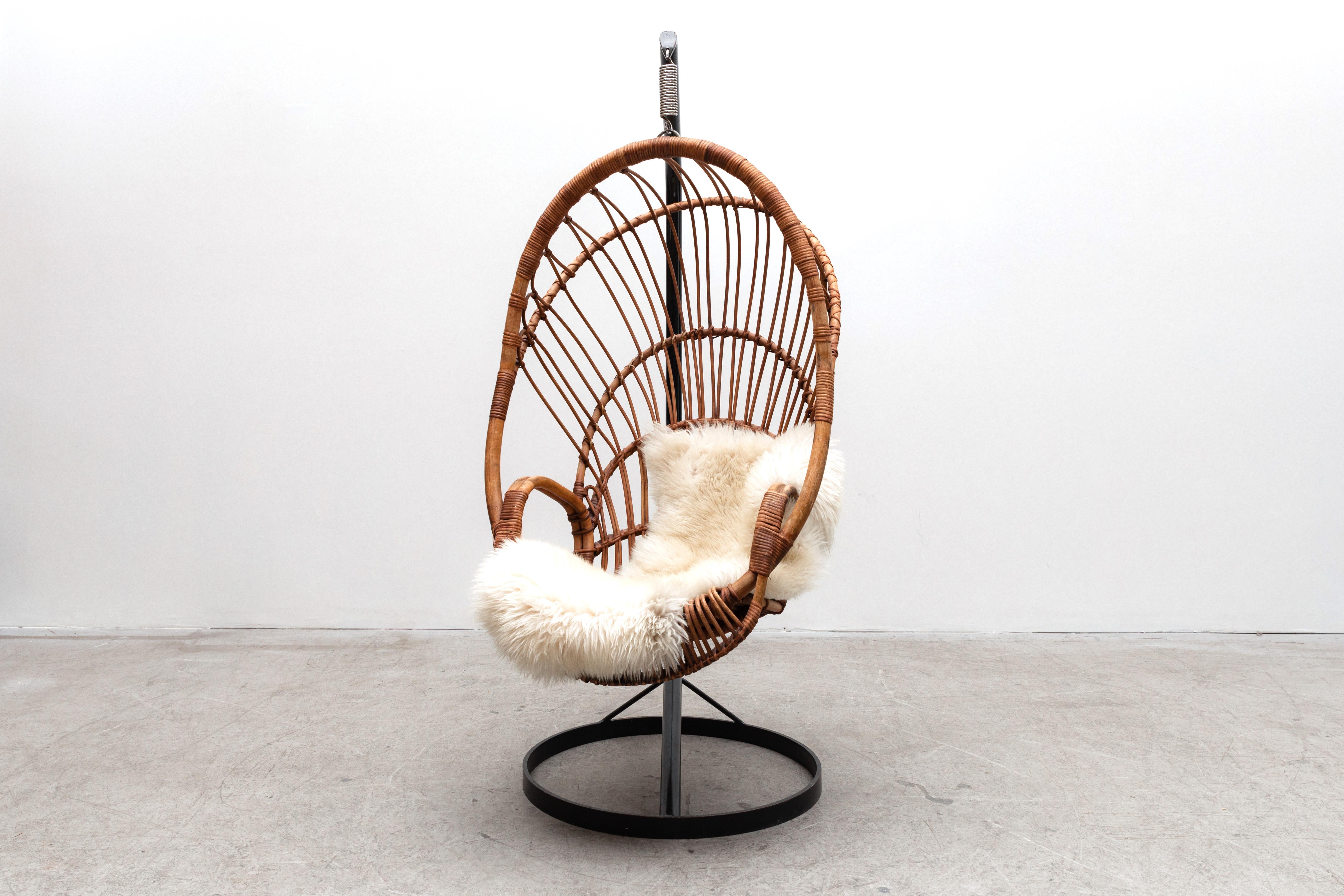 Beautifully Woven Rohé Noordwolde (attr) Rattan hanging basket chair with spring support on heavy black enameled metal frame. May have some rattan loss. In original condition with nice patina and visible wear consistent with its age and usage.