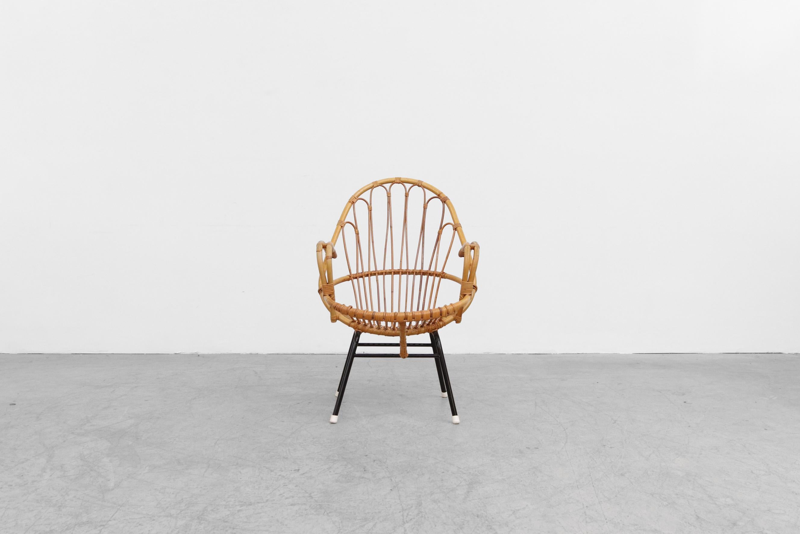 Mid-Century bamboo armchair with Decorative back and black tubular metal base. In original condition with wear consistent with its age and use. Suitable for outdoor use with proper care and maintenance under dry, protected, covered area and covered