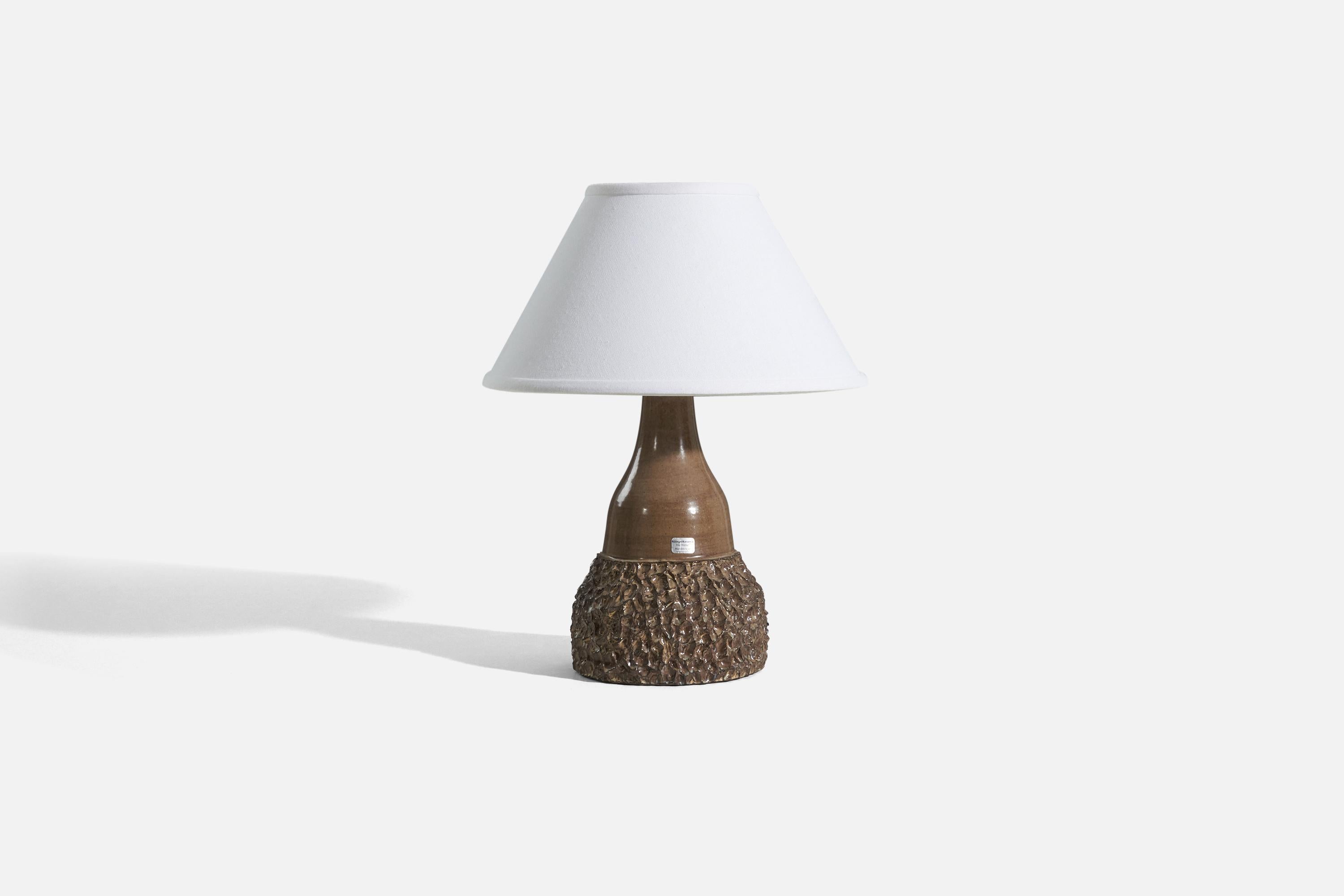 A brown glazed stoneware table lamp designed and produced by Röinge Keramik, Sweden, 1960s. 

Sold without lampshade. 
Dimensions of Lamp (inches) : 12.4375 x 6.125 x 6.125 (H x W x D)
Dimensions of Shade (inches) : 5 x 12.25 x 7.25 (T x B x