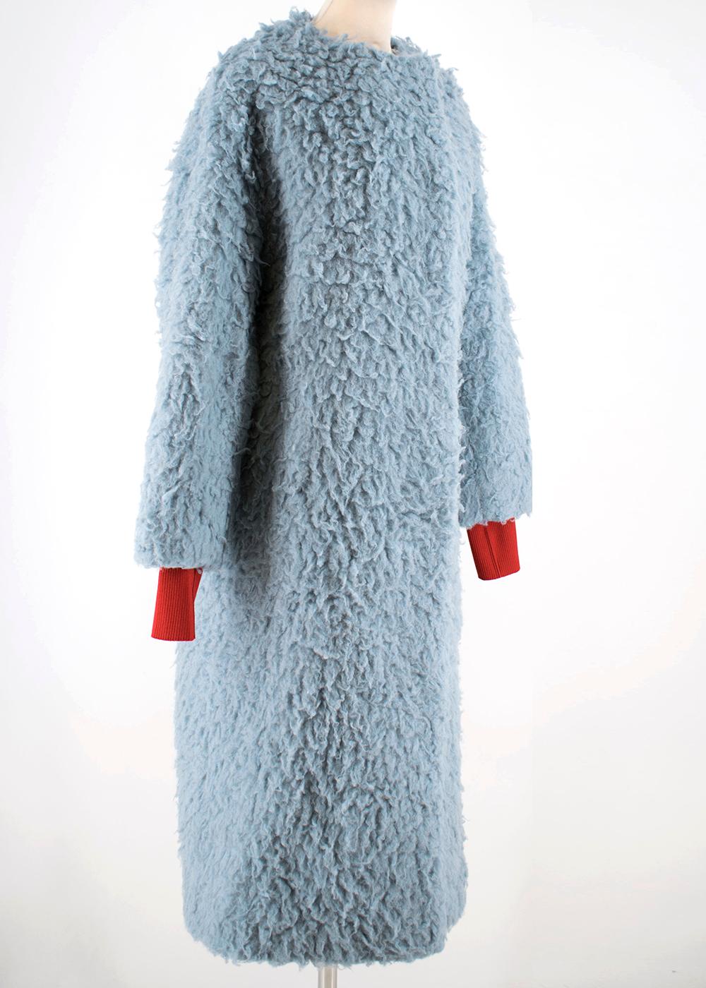 From the Fall 2018 Collection. Pale blue Roksanda Edine camel wool coat with dual slit pockets and hook closures at front, featuring an accented red ribbed cuff on the sleeves. RRP £1500

Fabric: 81% Camel Wool, 19% Silk; Lining 100% Silk 

Please