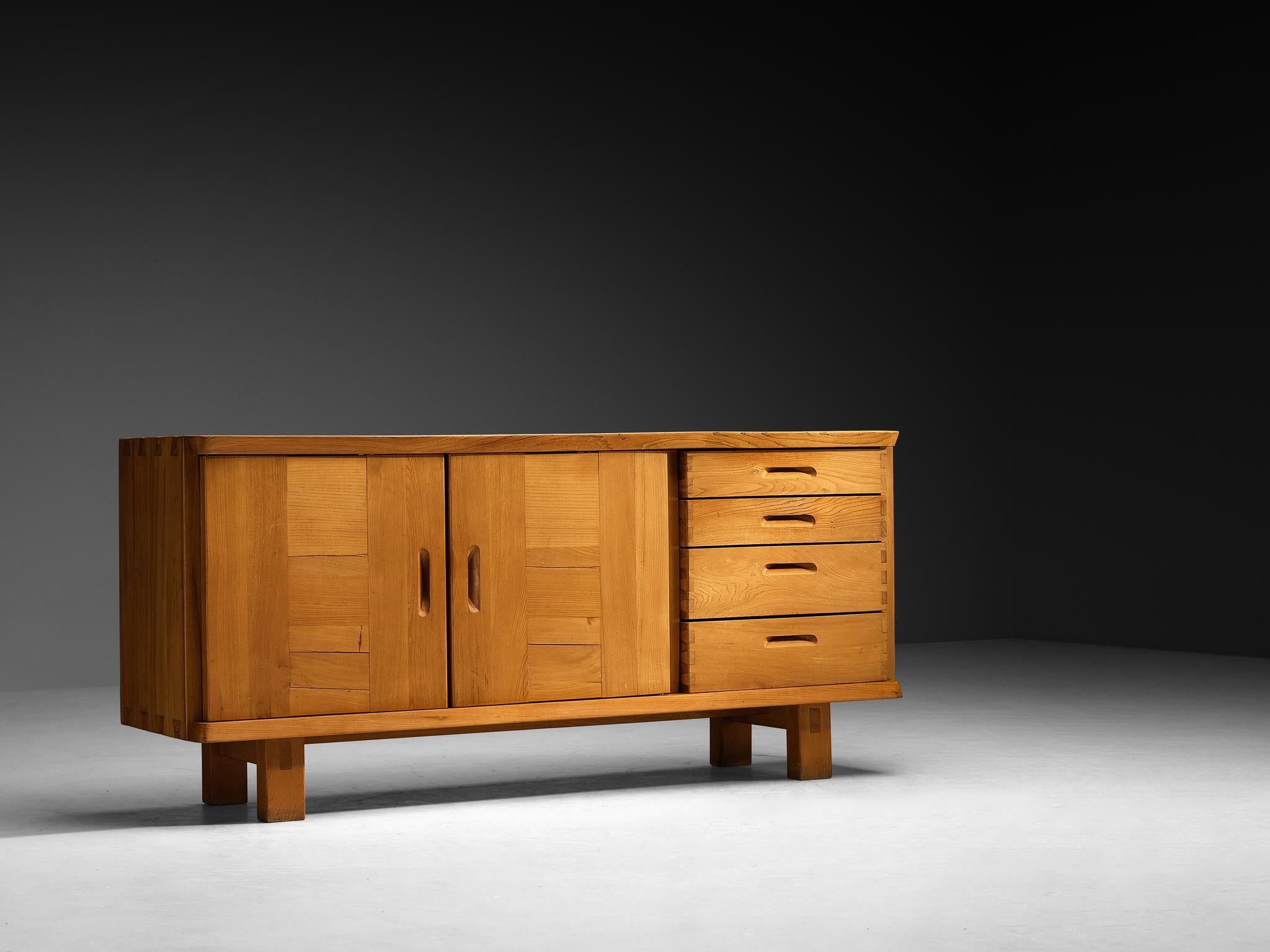Roland Haeusler per Maison Regain, credenza, olmo massiccio, Francia, anni '60

Questa credenza degli anni '60, disegnata da Roland Haeusler per Maison Regain, esemplifica l'impegno dell'Atelier A nella costruzione in legno massiccio e nella