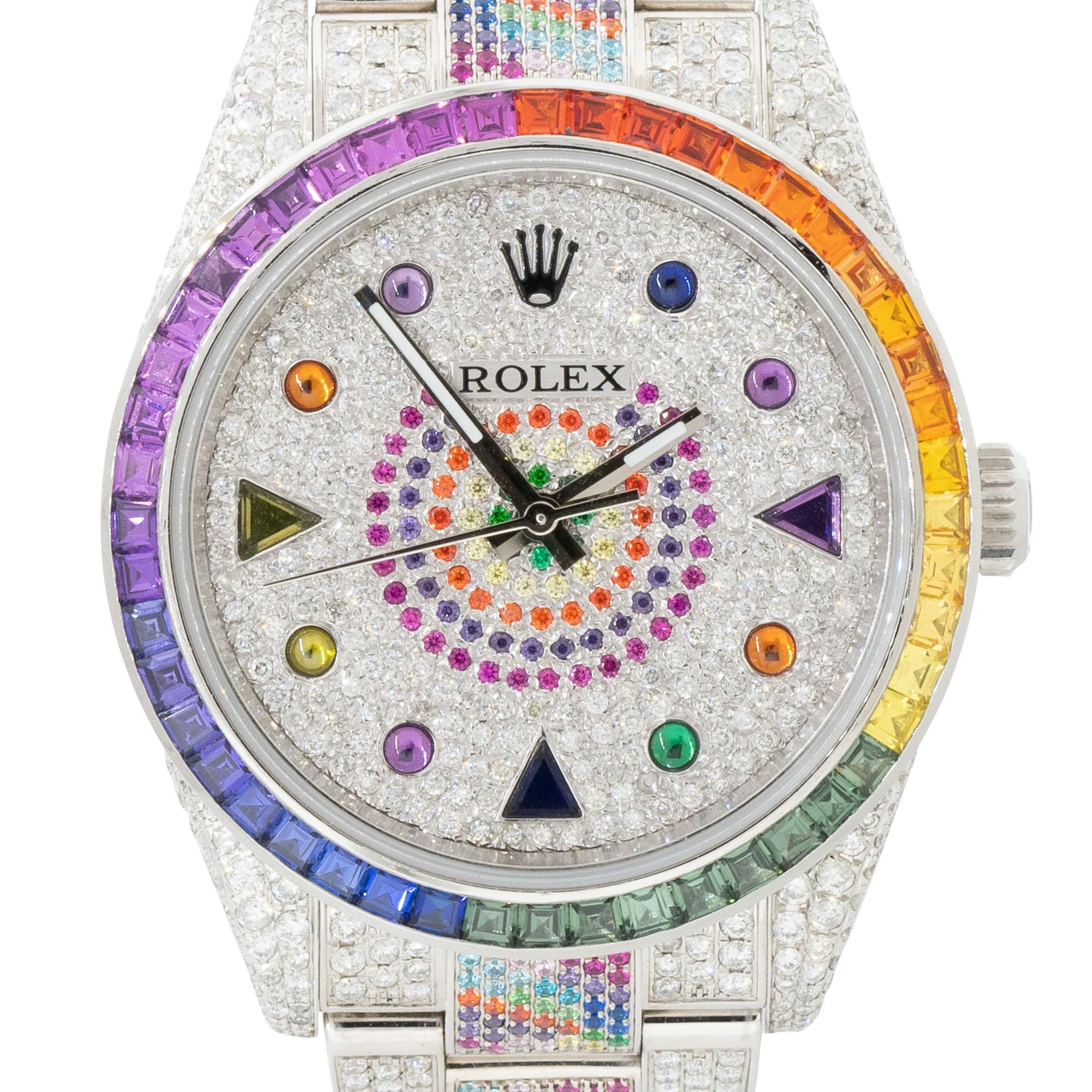 Brand: Rolex
MPN: 114300
Model: Oyster Perpetual
Case Material: Stainless Steel
Case Diameter: 39mm
Crystal: Sapphire Crystal
Bezel: Multi colored gemstone bezel (Aftermarket)
Dial: All Diamond, multi colored stone dial with silver hands and multi