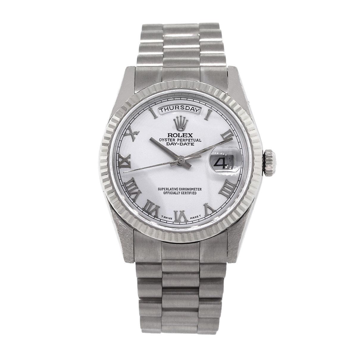 Brand: Rolex
MPN: 118239
Model: Day Date
Case Material: 18k White Gold
Case Diameter: 36mm
Crystal: Scratch resistant sapphire
Bezel: 18k White Gold Fluted Bezel
Dial: White dial with silver roman numerals. Date window at the 3 o’clock position. Day