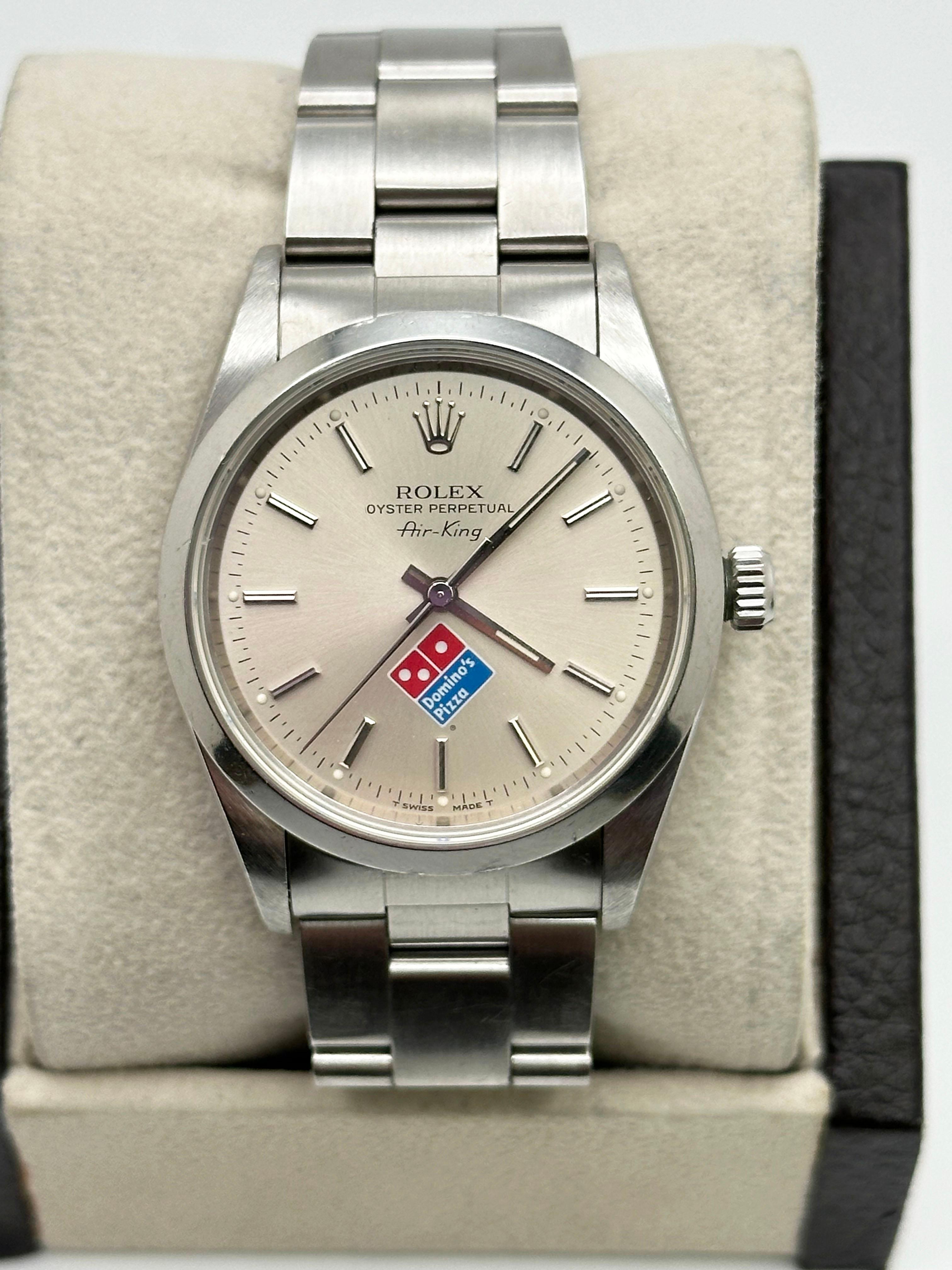 Style Number: 14000
Serial: T567***
Year: 1996
Model: Air King 
Case Material: Stainless Steel 
Band: Stainless Steel 
Bezel: Stainless Steel  Smooth Bezel 
Dial: Silver Dial with Rare Dominos Logo
Face: Sapphire Crystal 
Case Size: 34mm
Includes: