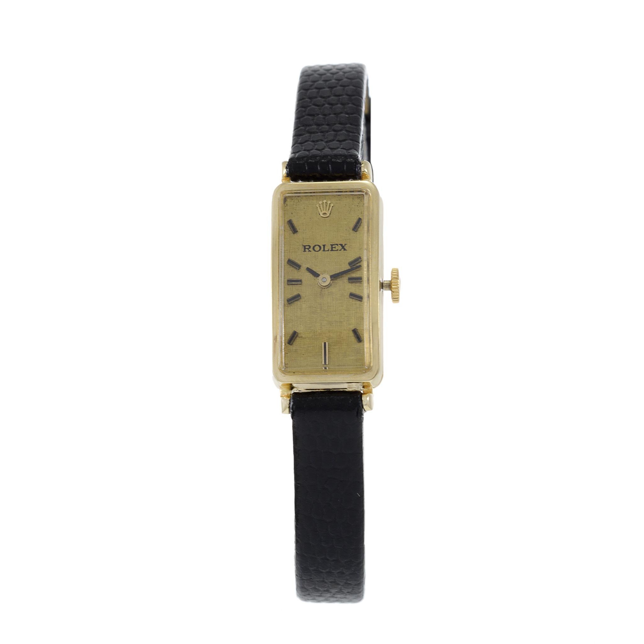Introducing the Rolex 1980's Circa 14KT Gold ladies Watch – a vintage marvel with a distinctive 11 x 25mm rectangle-shaped case. This elegant timepiece features a gold dial adorned with sleek black markers, exuding a sense of classic