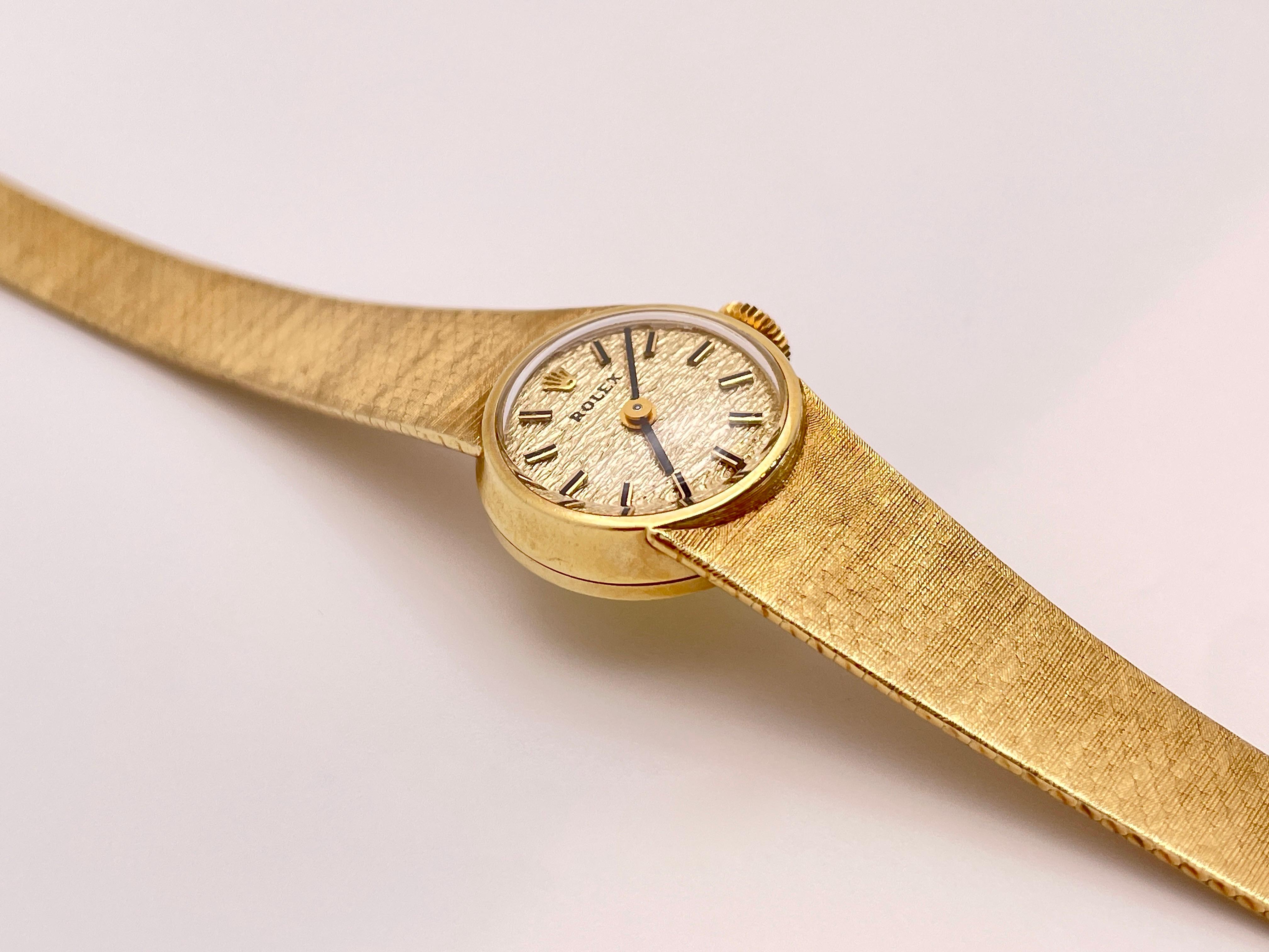 Ancienne montre de femme à remontoir Rolex en or jaune 14 carats, entièrement fonctionnelle. Le bracelet est flexible et présente une finition satinée. Boucle, bracelet, cadran et mouvement d'origine. 

Poids brut : 26,70 grammes
Longueur : 6,75