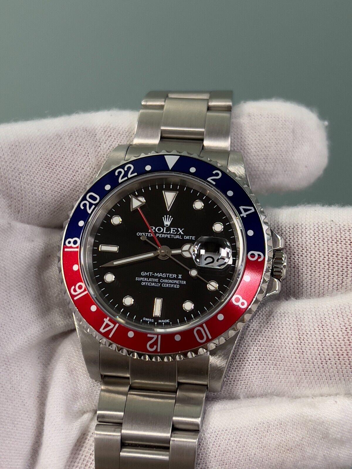 Style Number: 16710
Serial: Y320***
Year: 2002
Model: Rolex GMT Master II 
Case Material: Stainless Steel 
Band: Stainless Steel 
Bezel: Pepsi- Red and Blue 
Dial: Black 
Face: Sapphire Crystal 
Case Size: 40mm 
Includes: 
-Elegant Watch