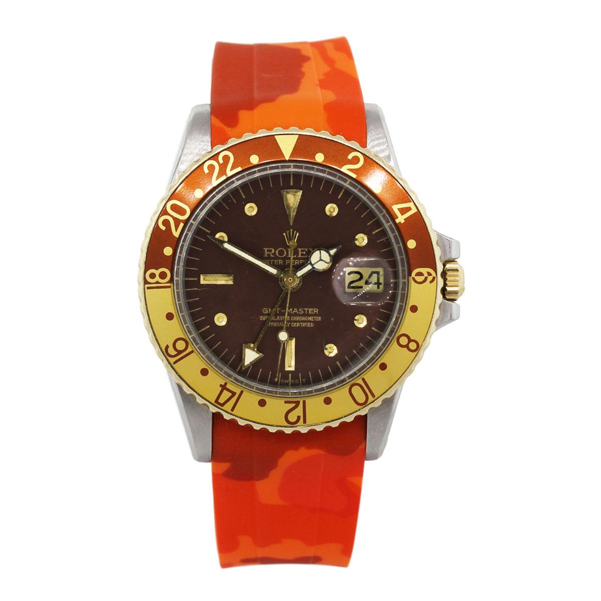 Brand: Rolex
MPN: 1675
Model: GMT-Master (root beer)
Case Material: Stainless steel
Case Diameter: 40mm
Crystal: Plastic
Bezel: Yellow and brown bidirectional bezel
Dial: Brown dial with date window and the 3 o’clock position
Bracelet: Horus orange