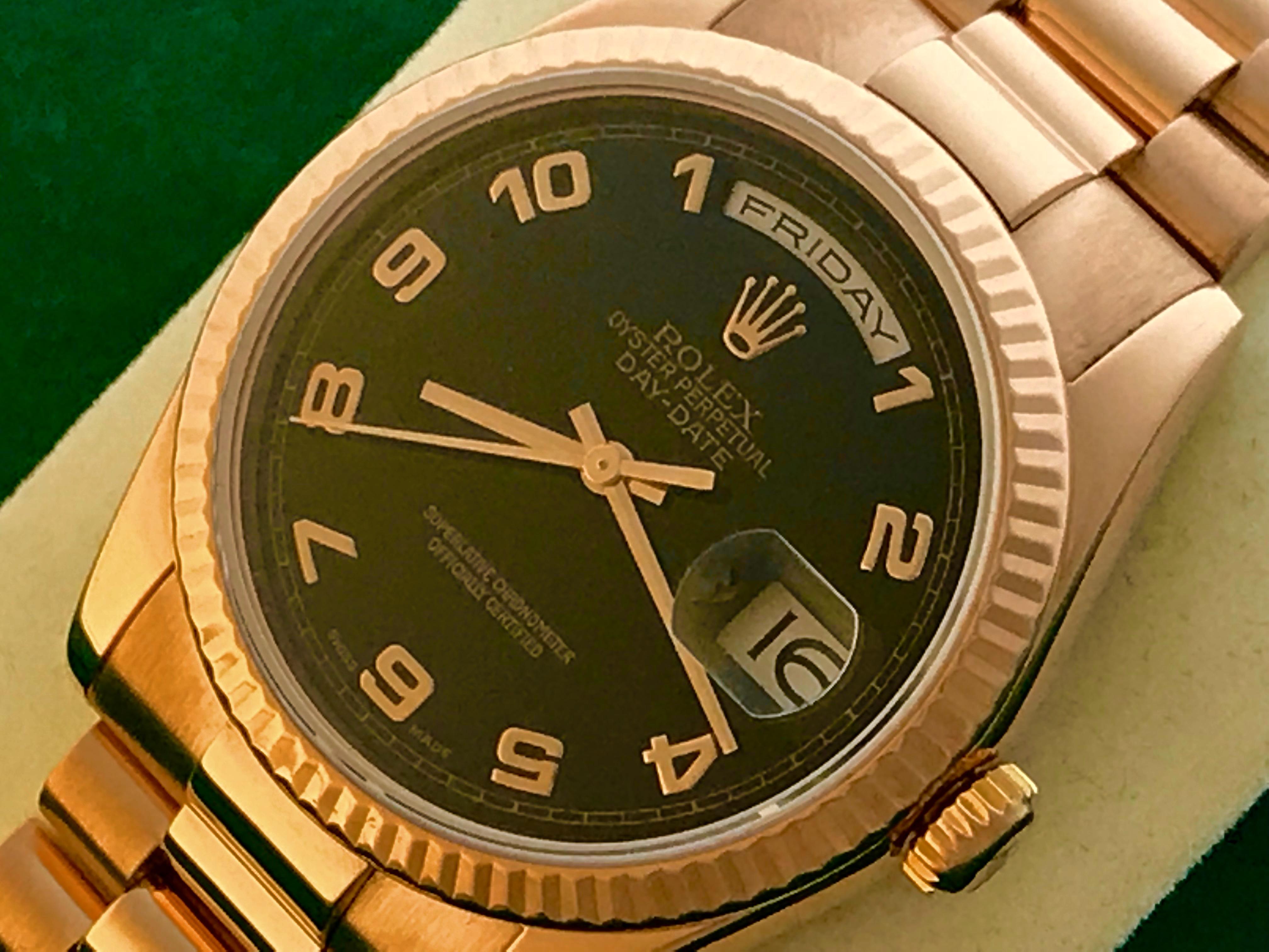 Rolex President Day-Date Model 118235 Pre Owned Mens  Automatic wrist watch. Black Dial with Rose gold Arabic numerals. 18k Rose Gold case with fluted bezel (36mm). 18k Rose Gold Oyster President bracelet. Rolex box and instruction booklet included