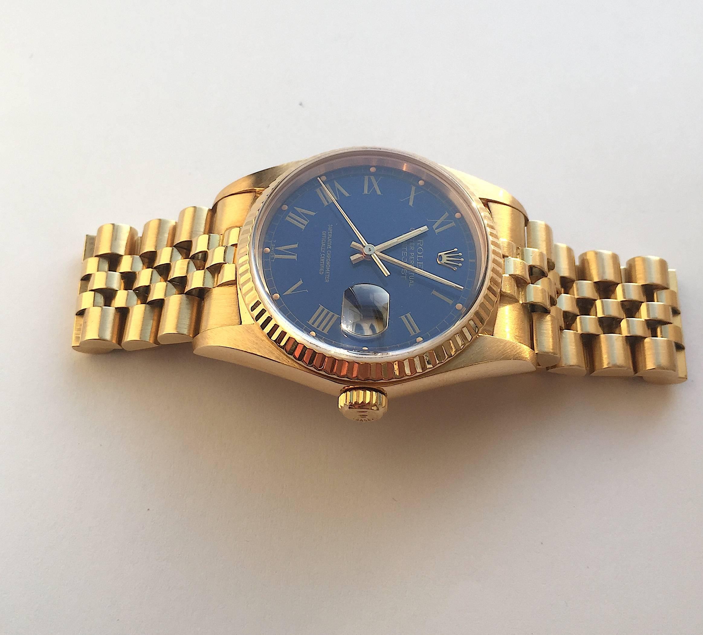 Rolex 18K Yellow Gold Oyster Perpetual Datejust Wristwatch
Factory Blue 'Buckley' Dial with  Roman Numeral Markers with Creamy Pumpkin Colored Lume Plots
18K Yellow Gold Fluted Bezel
36mm in size 
Rolex Calibre Base 3035 Automatic Quick-Set