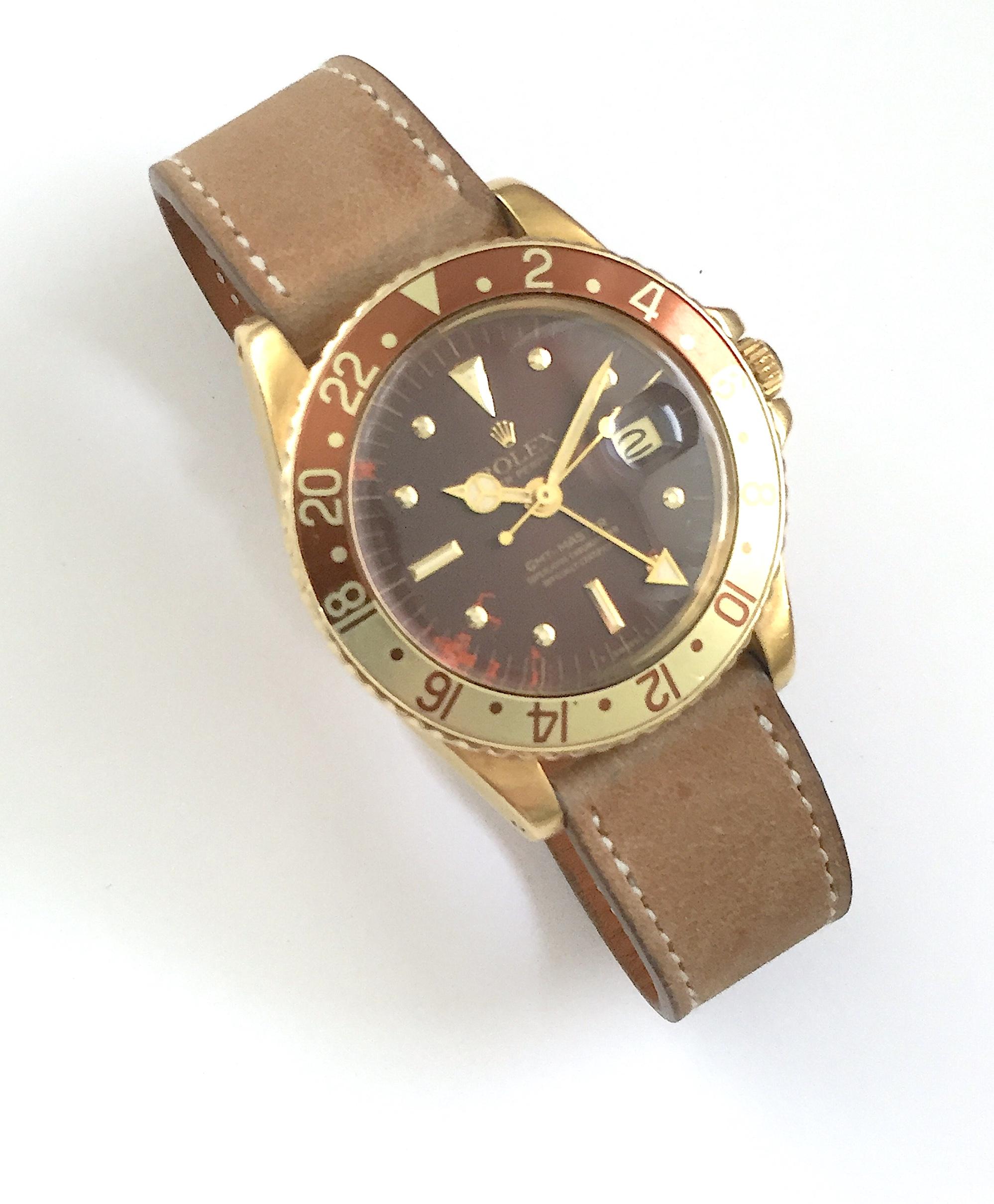 Rolex 18K Yellow Gold Oyster Perpetual GMT Master Watch
Reference 1675 with 18K Yellow Gold Case
Bi-Color 'Root-Beer' Rotating Bezel
Featured GMT Hand for Dual Time Zone Functionality
Brown Gloss Nipple Dial with Natural Tropical Fading and Color