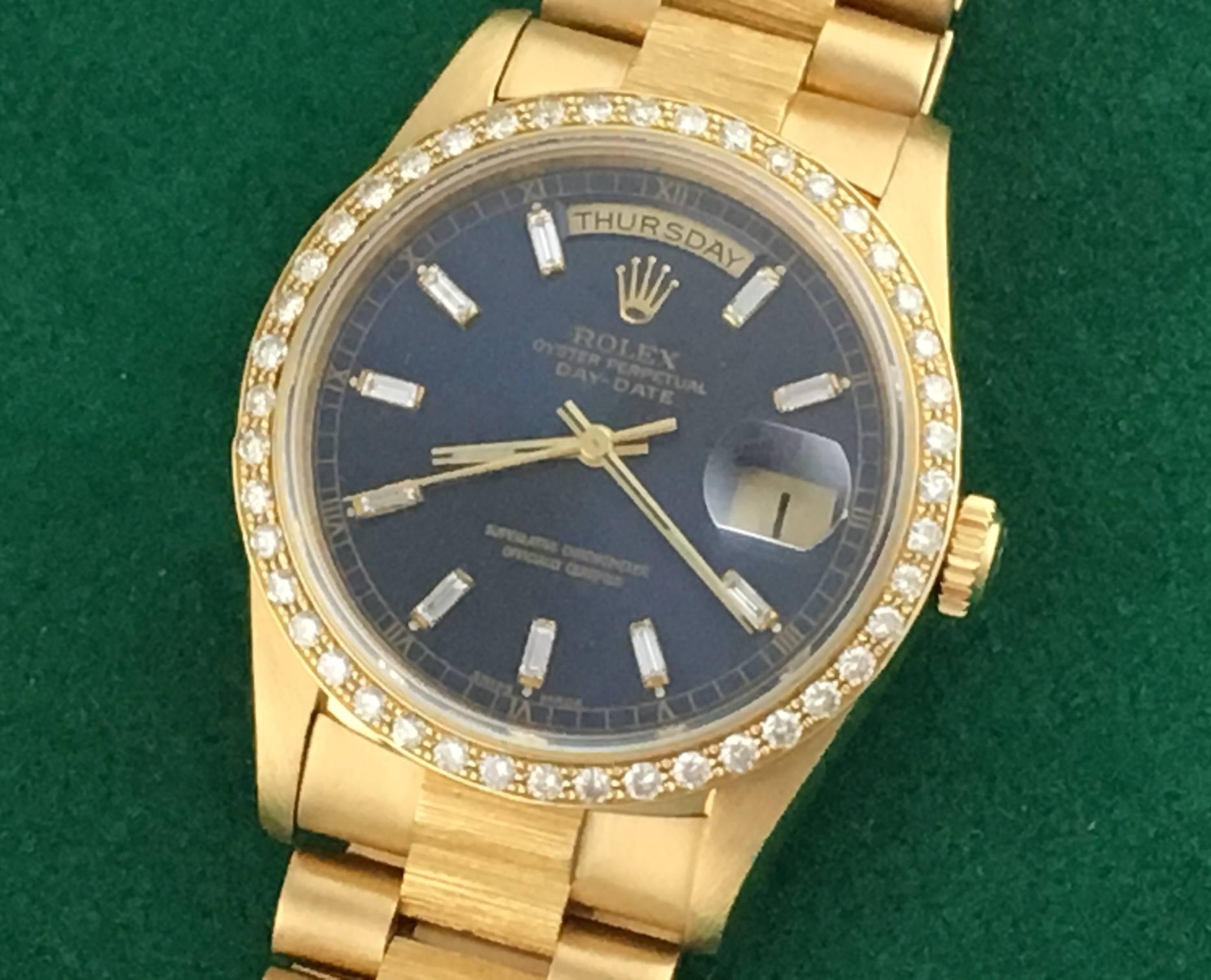 Rolex President Day-Date Model 18248 Pre Owned Mens Automatic Oyster Perpetual wrist watch. Featuring a Blue Dial with custom baguette Diamond hour markers, 18k Yellow Gold case with custom Diamond bezel and measures 35mm. 8k Yellow Gold hidden
