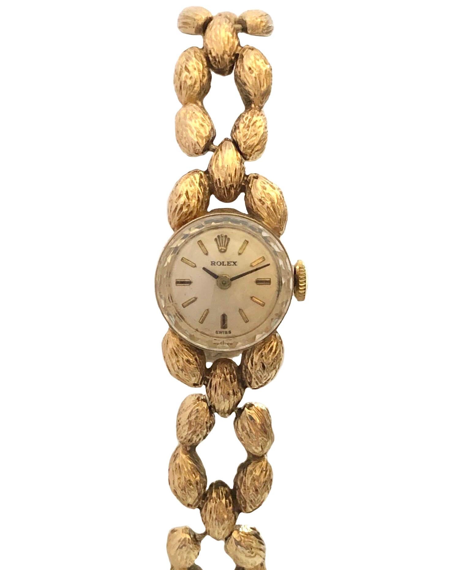 Circa 1960s Ladies Rolex Bracelet Wrist Watch, 15 M.M.  14K yellow Gold 2 Piece case, 17 Jewel mechanical, Manual wind movement, original Silver, Satin Dial with raised Gold markers, Rolex logo Crown. 7/16 inch wide textured link bracelet with Rolex