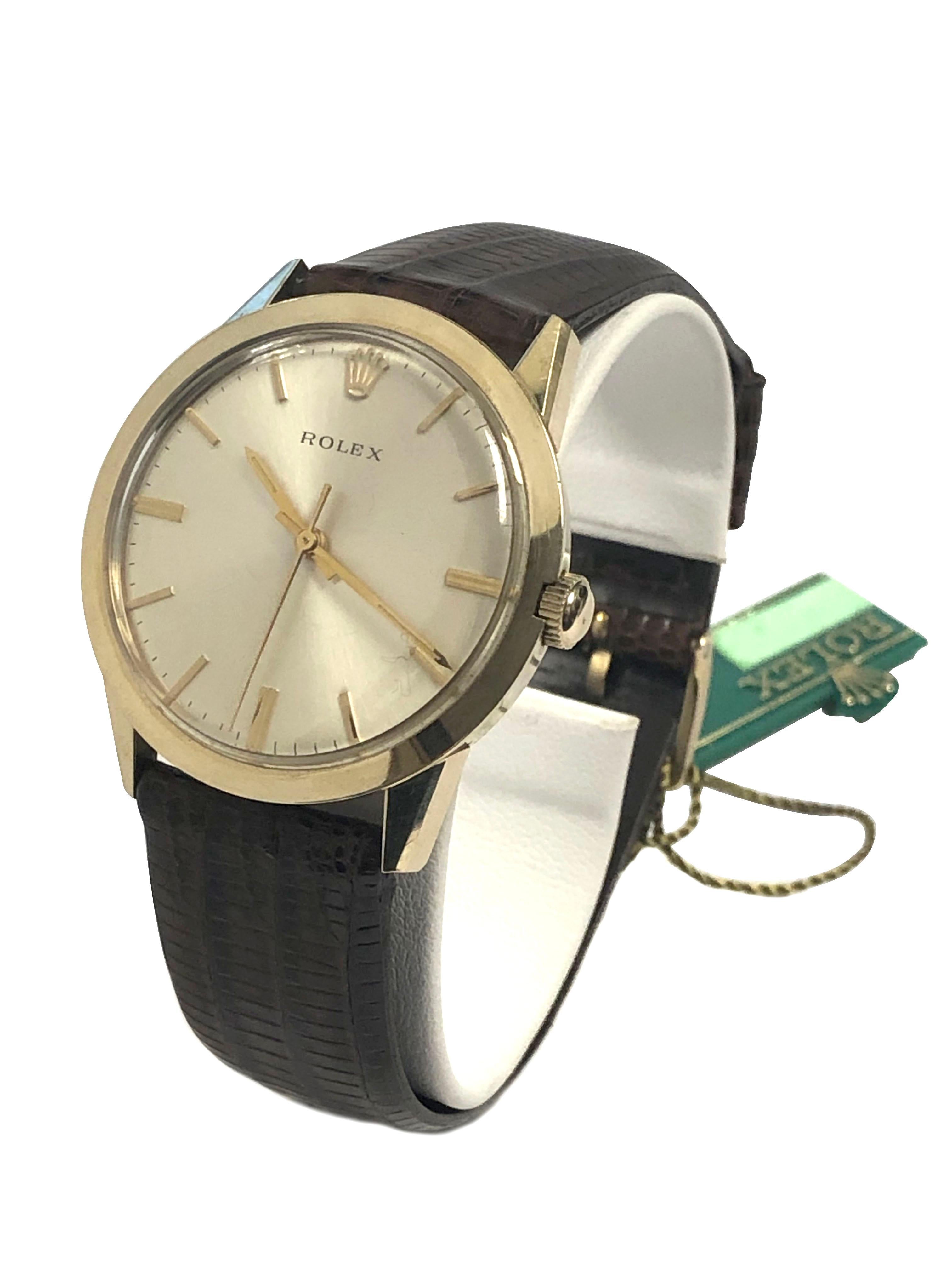 Circa 1970 Rolex Presentation Watch, 35 M.M. X 10 M.M. Thick 14k Yellow Gold Filled 2 piece case. Automatic self winding movement, silver satin dial with raised Gold markers and a center sweep hand, Brown Lizard Strap with Gold Filled Rolex Buckle.