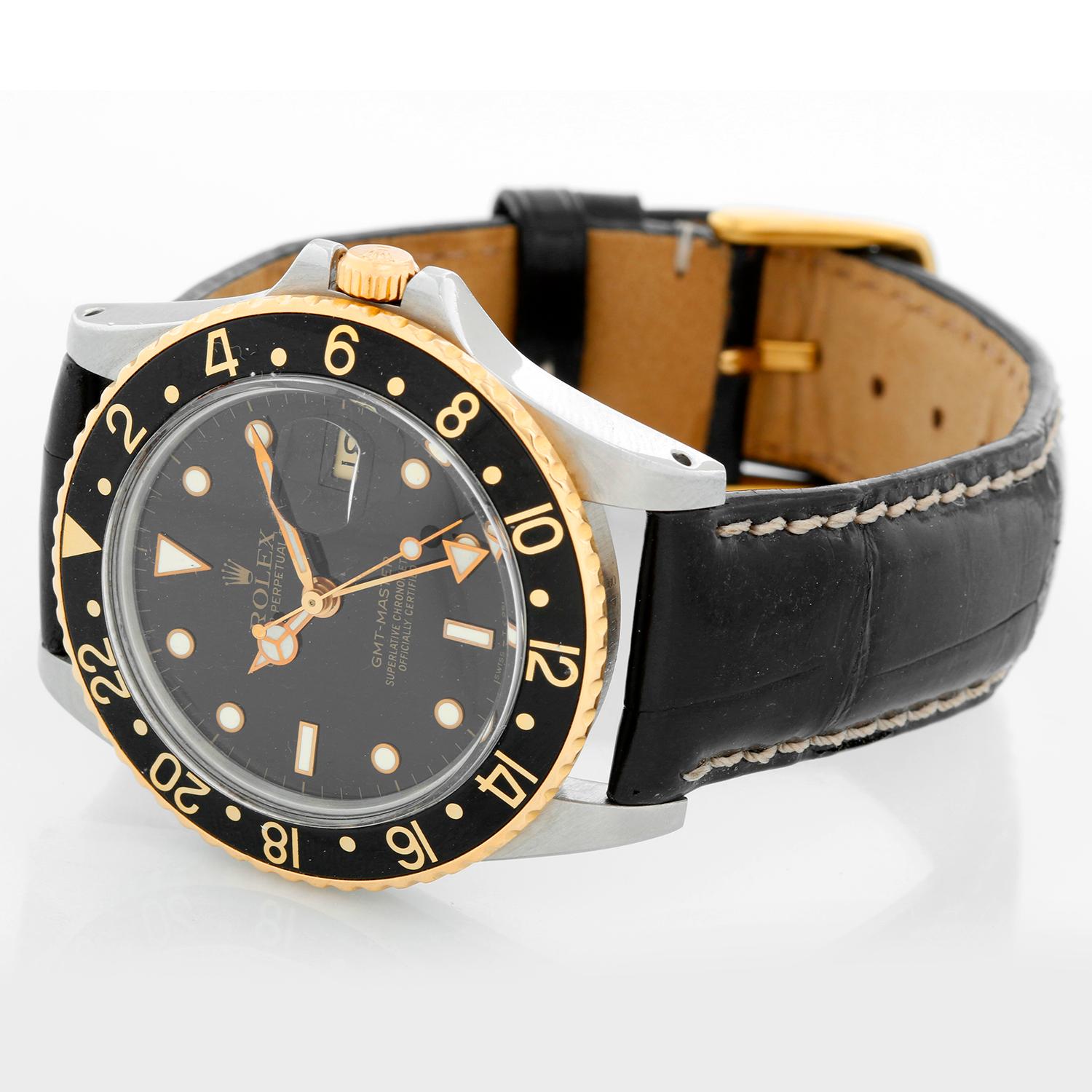 Rolex 2-Tone GMT-Master 16753 on a Strap - Automatic winding. Stainless steel with gold bezel ( 40 mm ). Black dial with gold framed hour markers with date. Black alligator strap with tang buckle. Pre-owned with Rolex box and books
