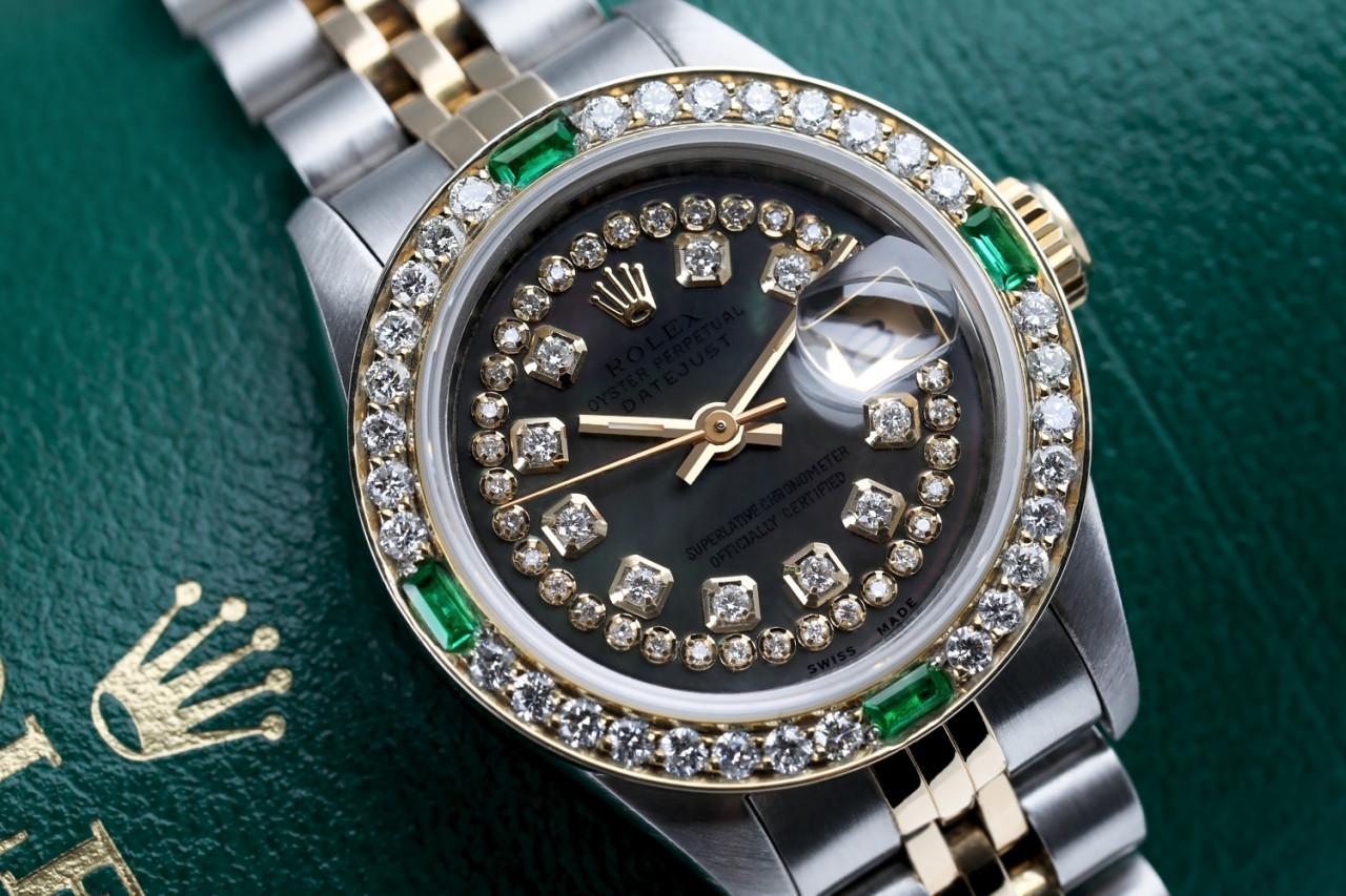 Ladies Rolex 26mm Two Tone Black MOP Mother of Pearl String Diamond Dial Vintage Diamond Bezel with Emeralds 69173

This watch is in like new condition. It has been polished, serviced and has no visible scratches or blemishes. All our watches come