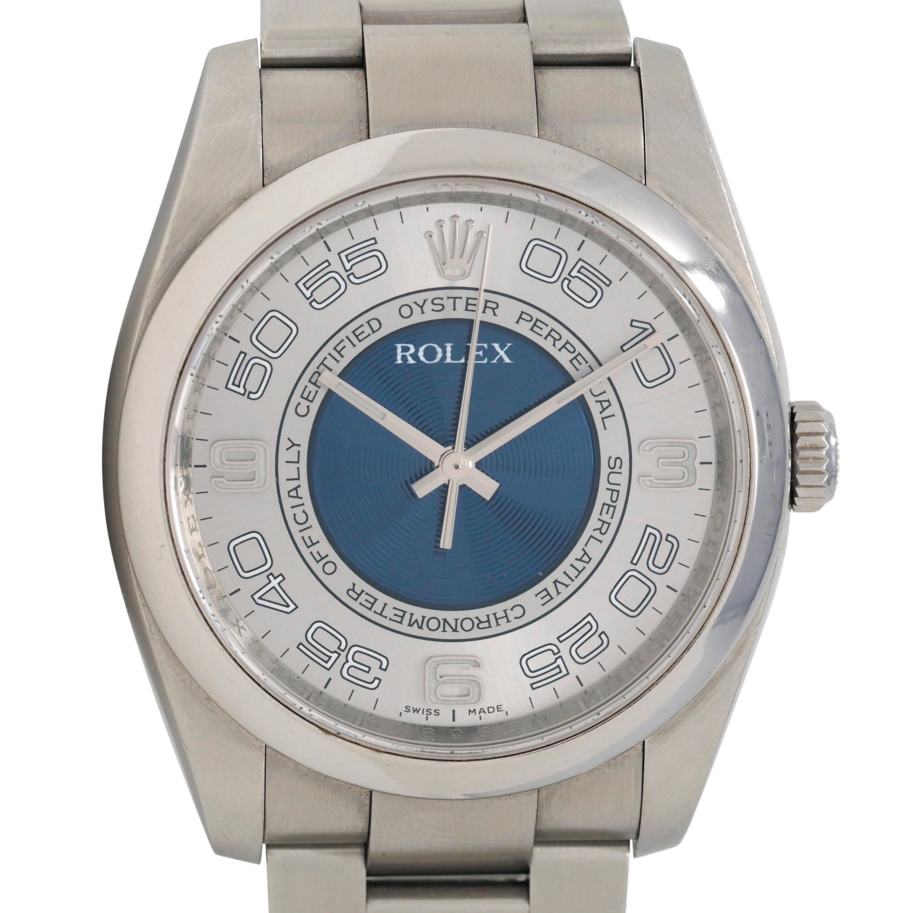 Centering a round silver and blue concentric dial watch face featuring white Arabic numerals 
With 'Rolex' and 'Swiss Made' Inscribed on face with raised logo and hidden logo halo
With glass cover and high polish bezel set in brushed stainless steel