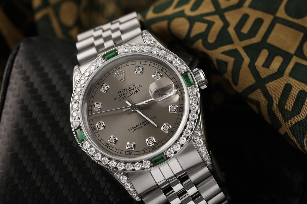 Rolex 36mm Datejust Dark Grey Diamond Dial with Diamond & Emerald Bezel & Diamond Lugs 16014
This watch is in like new condition. It has been polished, serviced and has no visible scratches or blemishes. All our watches come with a standard 1 year