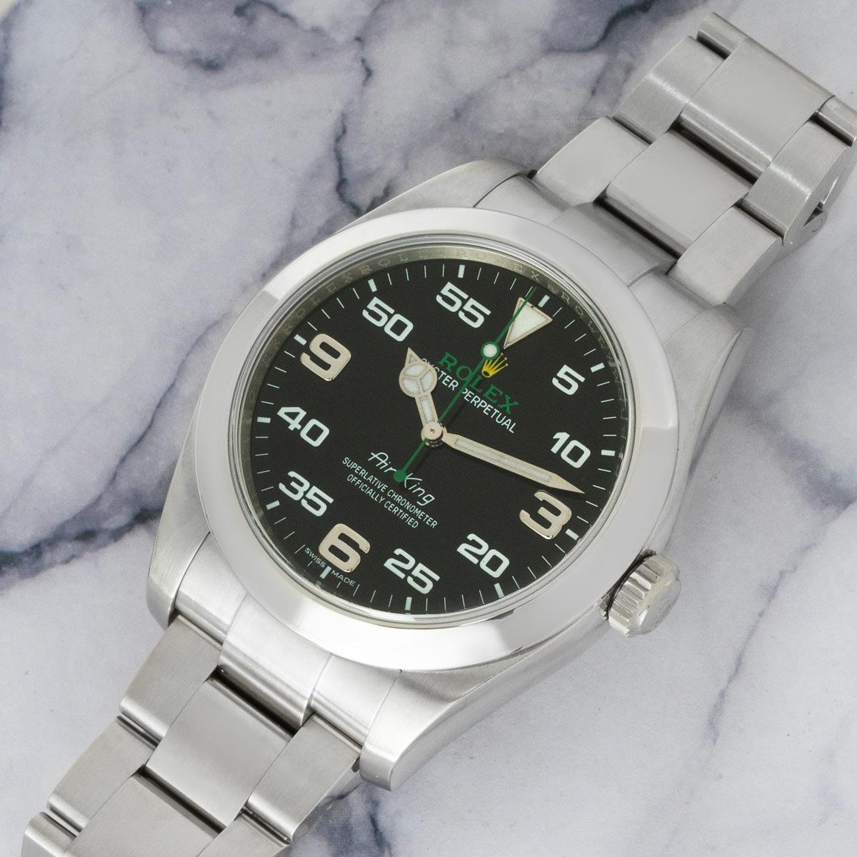 A 40mm Air-King in Oystersteel by Rolex. Features a black dial with Arabic numerals 3,6 and 9, complemented by a smooth fixed bezel. The Oyster bracelet comes with the folding Oysterclasp which is equipped with the Easylink 5mm comfort extension