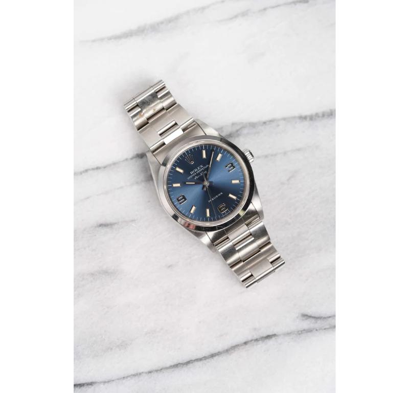 Aquí tienes un Rolex Air King Oyster Perpetual Precision automático con número de referencia 14000 y esfera azul con números arábigos y rayos de sol de la década de 2000. Las medidas incluyen una caja de ostras de 34 mm y una anchura de orejetas de