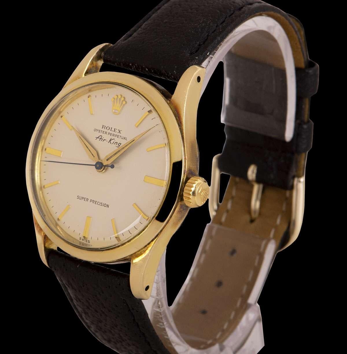 A 1960 34mm Gold Capped Oyster Perpetual Air-King Super Precision Vintage Gents Wristwatch, silver dial with applied hour markers, a fixed gold capped smooth bezel, a black leather strap with a gold plated pin buckle (both not by Rolex), plastic