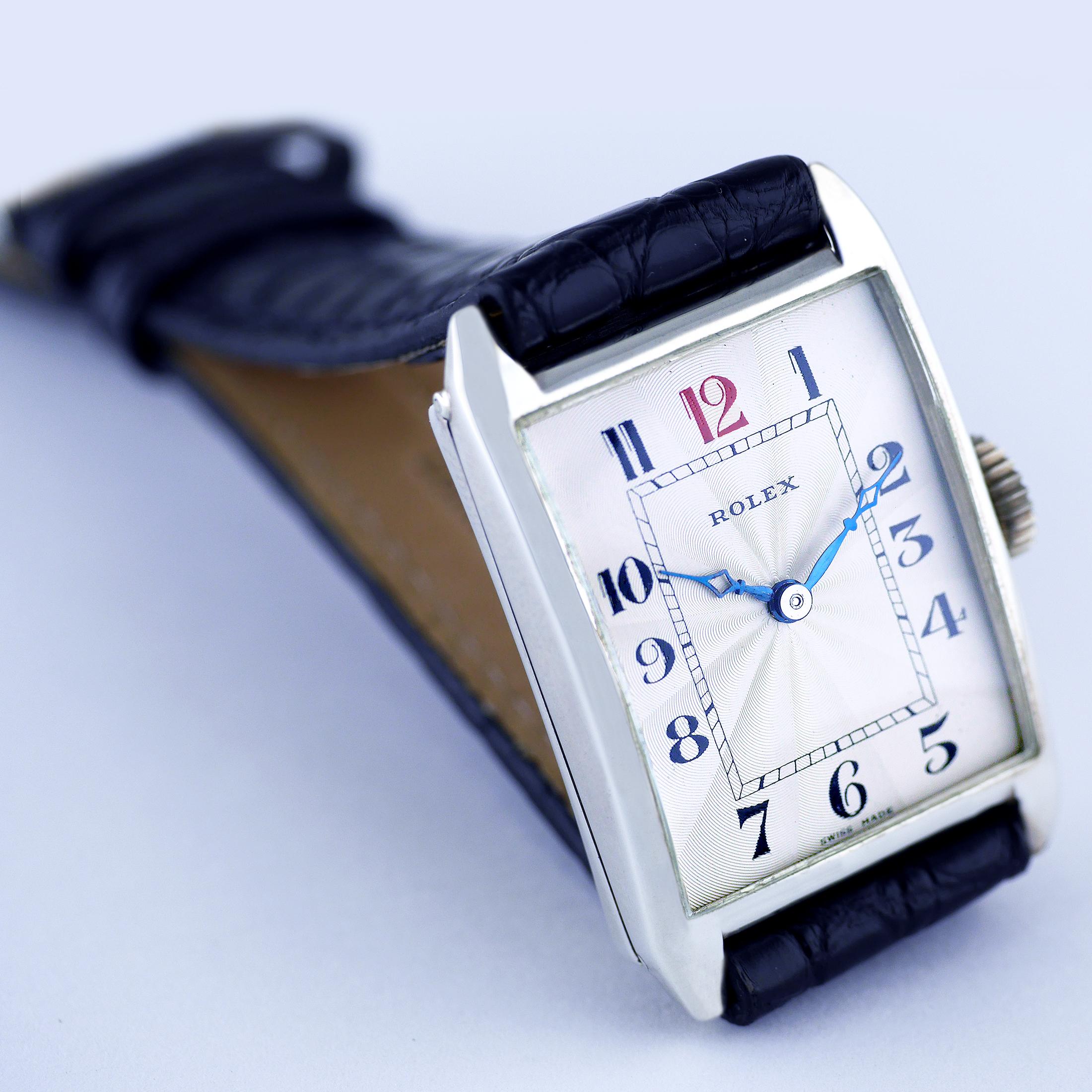 An Art Deco vintage wristwatch by Rolex made in 1925.

Silver rectangular shaped case marked with Rolex, 7 World’s Records, Gold Medal, Geneva, Suisse and the “RWC Ltd” lozenge for the Rolex Watch Company Ltd. The hinged back silver case, hallmarked