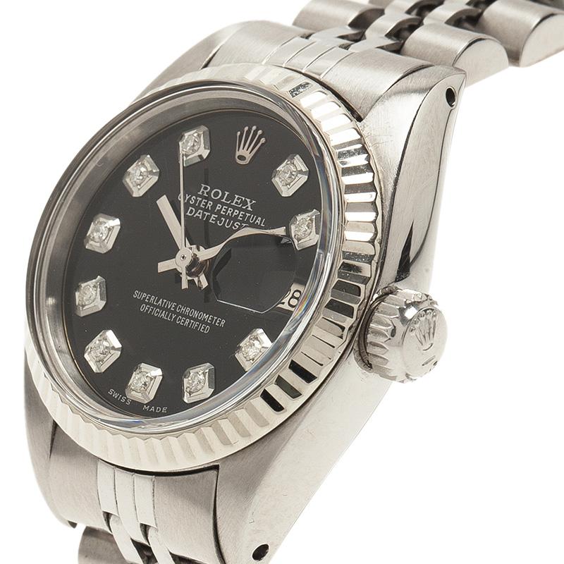 Feminine, smooth, and classy, this Rolex watch is a timepiece worthy of royals. Crafted from stainless steel, its case and chain bracelet has a smooth semi-matte texture that gives its design an opulence. The ribbed bezel surrounds a black dial with