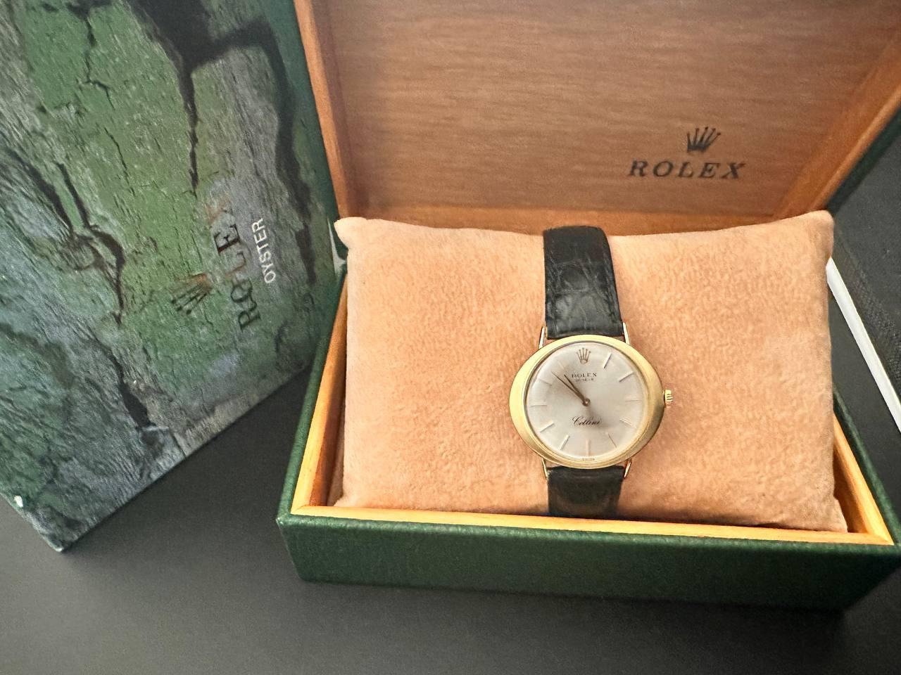 Rolex Cellini model 
Diameter 32mm 
Manual movement
Yellow gold material and black leather strap 
Oval-shaped gray dial 
The watch comes with the original box 
1 year warranty from date of purchase for malfunction 
