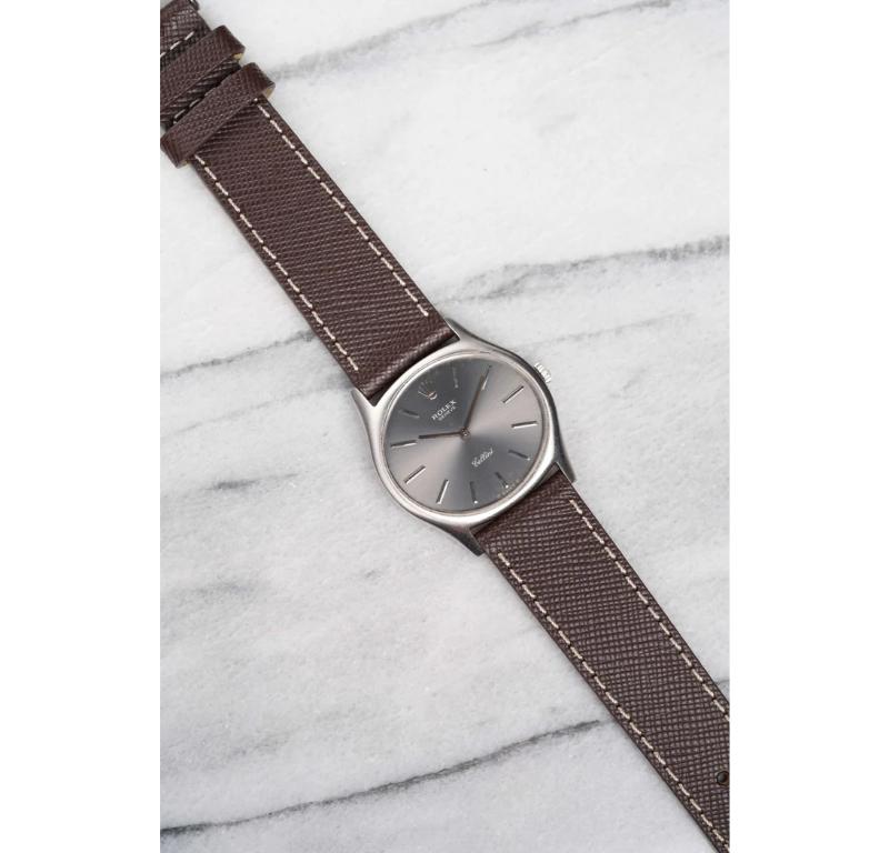 Aquí tienes un Rolex Cellini Reference vintage de cuerda manual de oro blanco de 18 quilates con esfera gris soleada de los años 70. Mantiene la hora y es totalmente funcional. Las medidas incluyen un tamaño de caja de 32 mm y una anchura de asa de