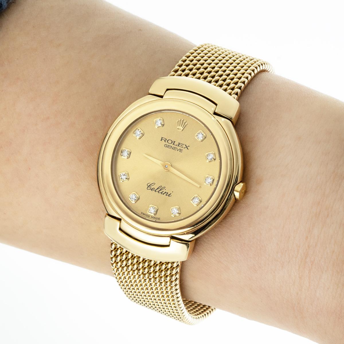 Une montre-bracelet Cellini en or jaune de Rolex. Cadran champagne avec index et chiffres sertis de diamants, lunette en or jaune. Équipée d'un bracelet intégré en or jaune et d'un fermoir déployant. La montre est également équipée d'un verre saphir