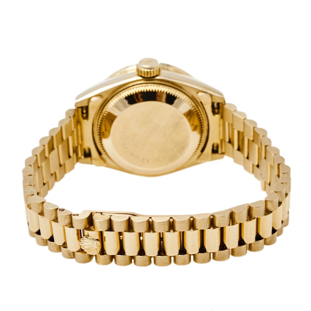 This stylish Swiss-made timepiece is sure to complete any woman's watch collection. The Rolex, Datejust 69158 features an 18k yellow gold diamond encrusted 26mm case, with a fixed bezel, a champagne dial, and a scratch-resistant sapphire crystal. It