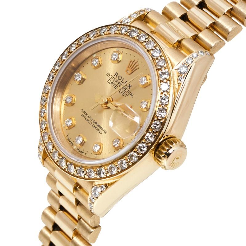 This stylish Swiss-made timepiece is sure to complete any woman's watch collection. The Rolex, Datejust 69158 features an 18k yellow gold diamond encrusted 26mm case, with a fixed bezel, a champagne dial, and a scratch-resistant sapphire crystal. It