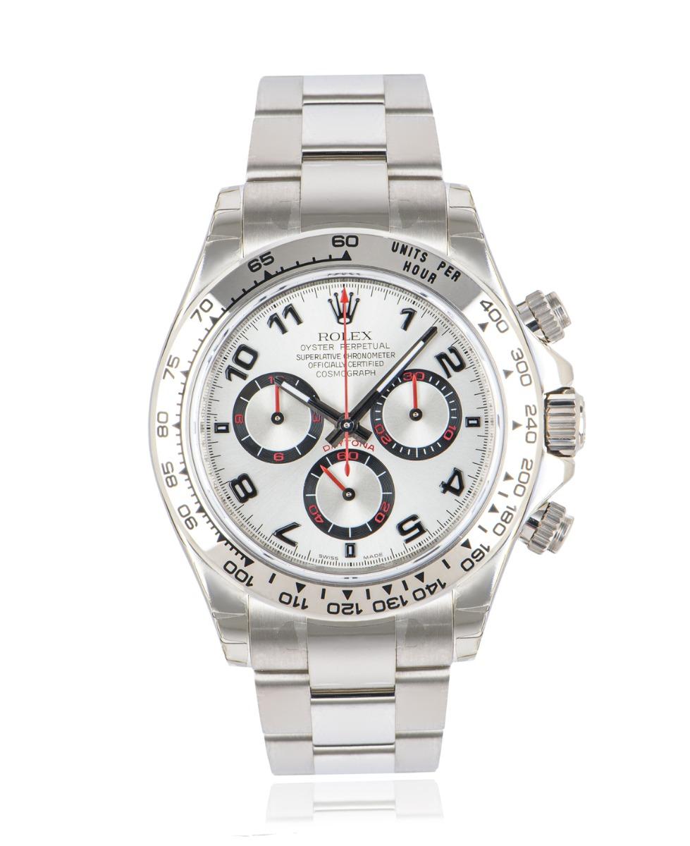 An unworn NOS 40mm Cosmograph Daytona in white gold by Rolex, featuring a silver racing dial with red detailing. Like all Daytona's this model features a tachymetric scale, three counters and three pushers, making it the ultimate high-performance