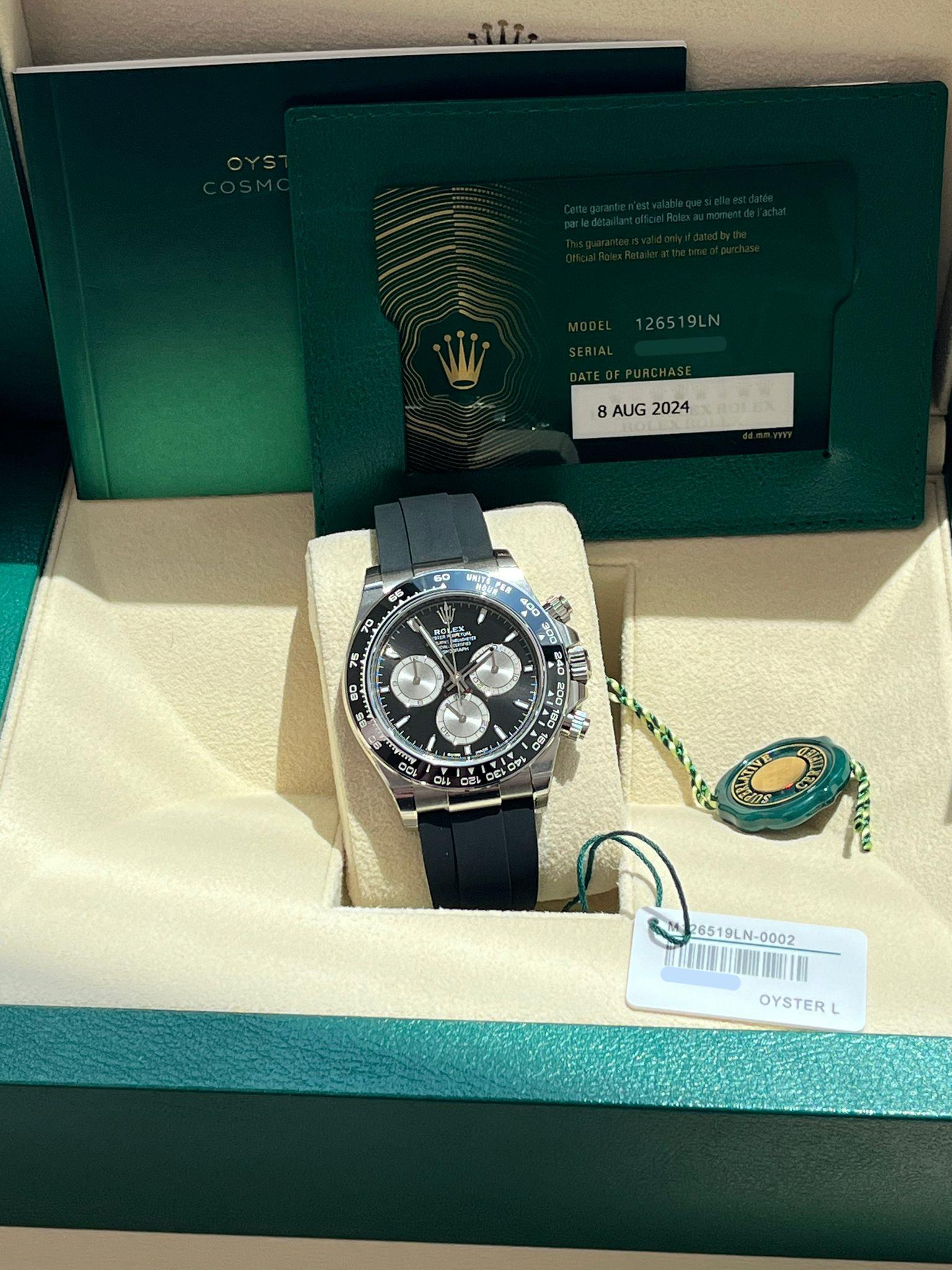 This Oyster Perpetual Cosmograph Daytona in 18 ct white gold, with a bright black and steel dial and an Oysterflex bracelet, features a black Cerachrom bezel with a tachymetric scale. The 18 ct gold versions of the Cosmograph Daytona with a