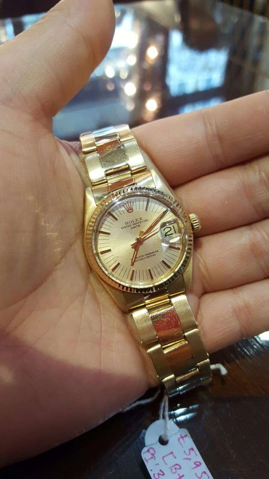 A 1970s 18k Yellow Gold Oyster Perpetual Date Mid-Size Wristwatch, champagne dial with applied hour markers, date at 3 0'clock, a fixed 18k yellow gold fluted bezel, an 18k yellow gold riveted oyster bracelet with an 18k yellow gold deployant clasp,