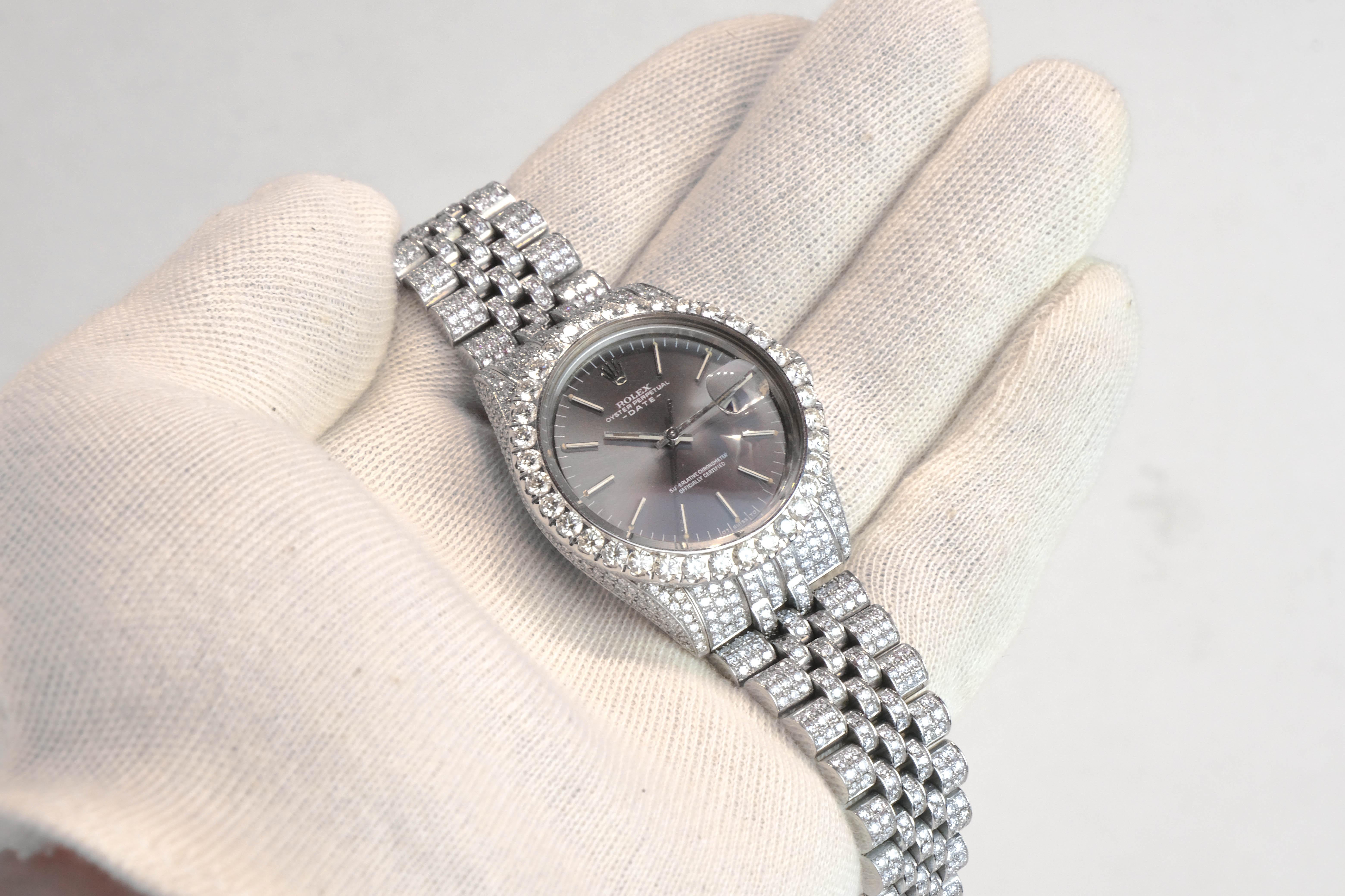 One gent's stainless steel Rolex Date Oyster Perpetual wristwatch. With a gray dial and date. It has been modified with round brilliant cut diamonds set throughout the bezel, lugs, sides and jubilee band measuring (approx. by gauge) 1.00mm-3.00mm,